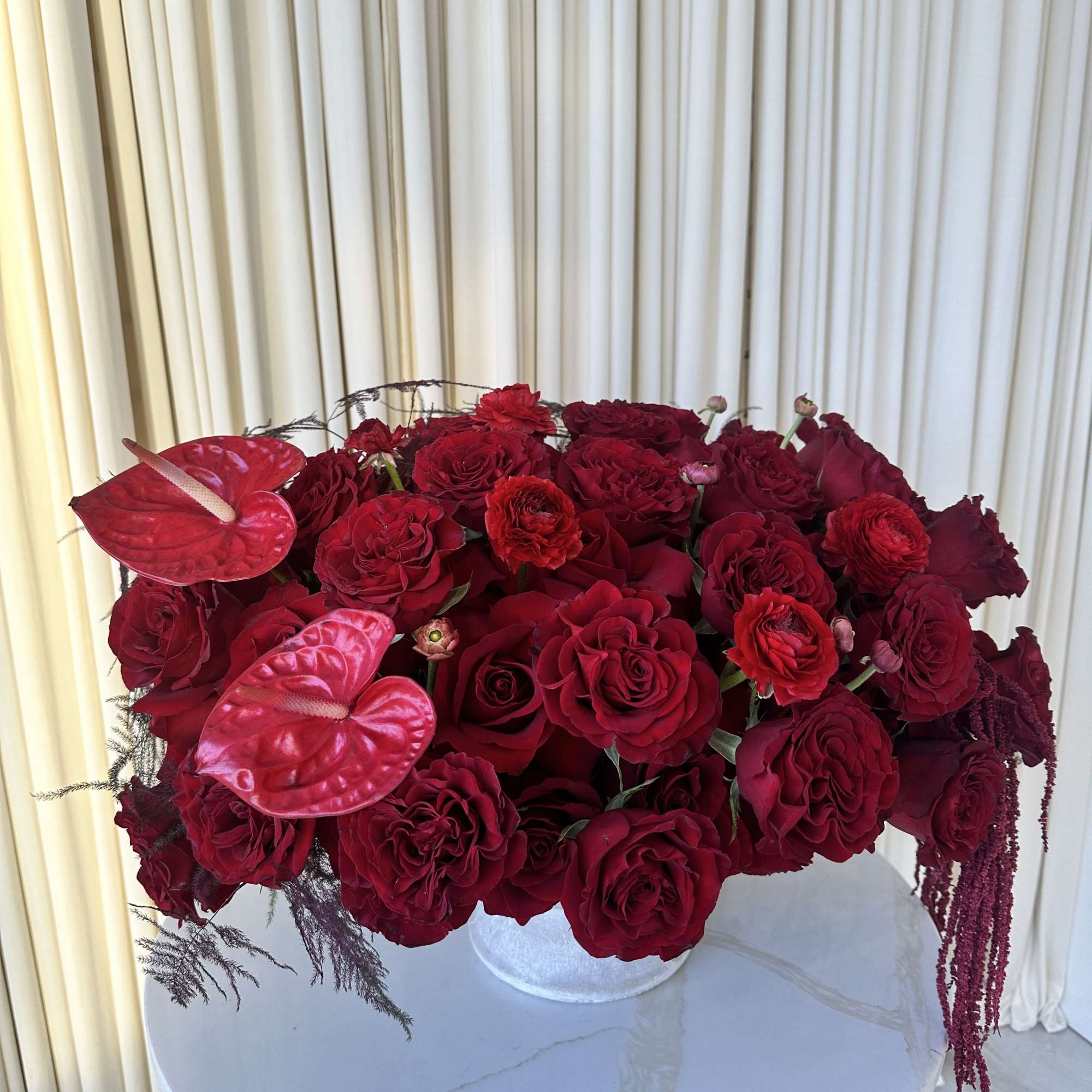 A lush mound of deep red roses and ranunculus creates the first
