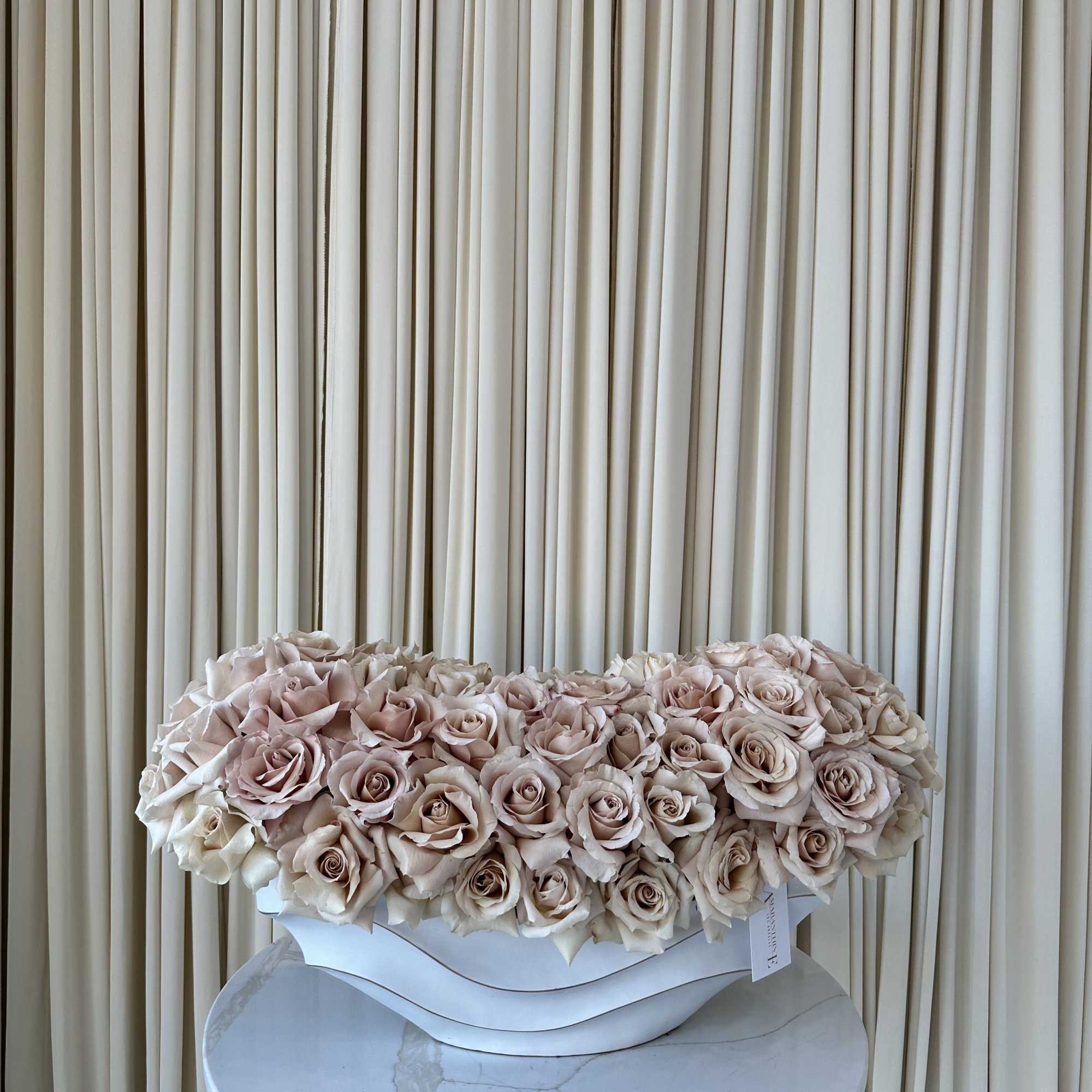 A cloud of pale blush and cream roses arranged as a low