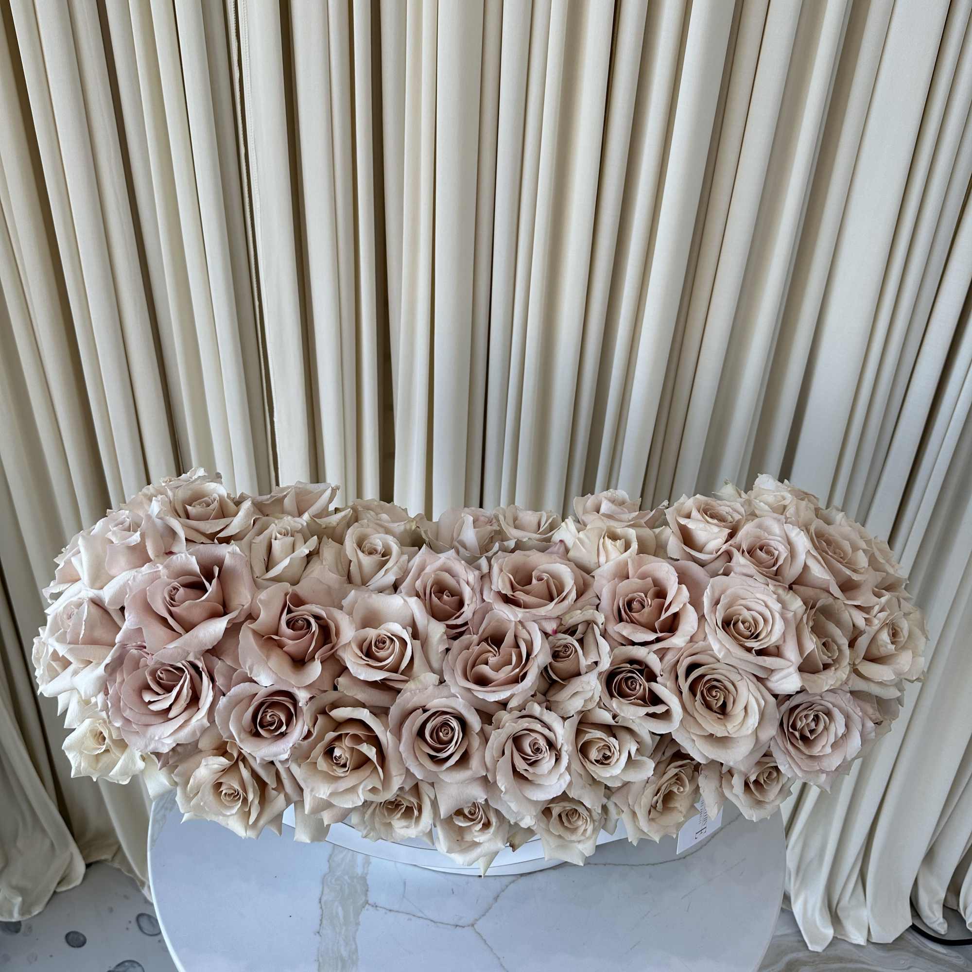 A cloud of pale blush and cream roses arranged as a low