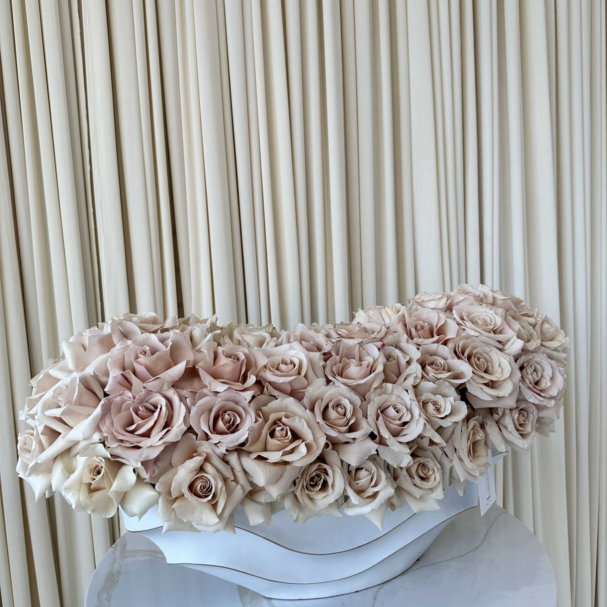 A cloud of pale blush and cream roses arranged as a low