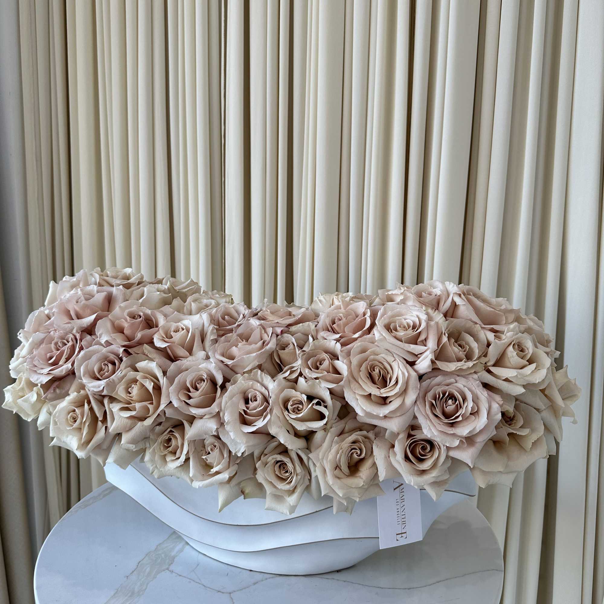 A cloud of pale blush and cream roses arranged as a low