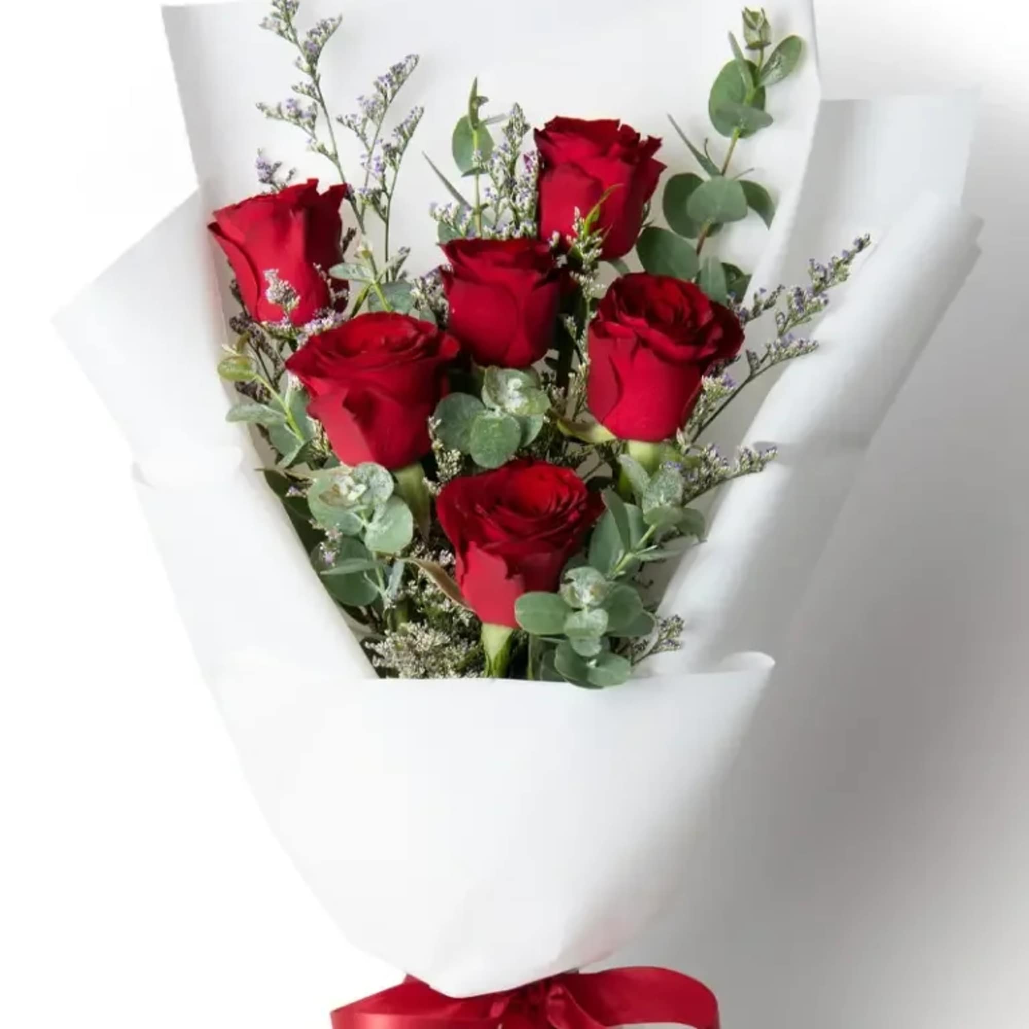 Bouquet of red roses wrapped in white paper with a red ribbon