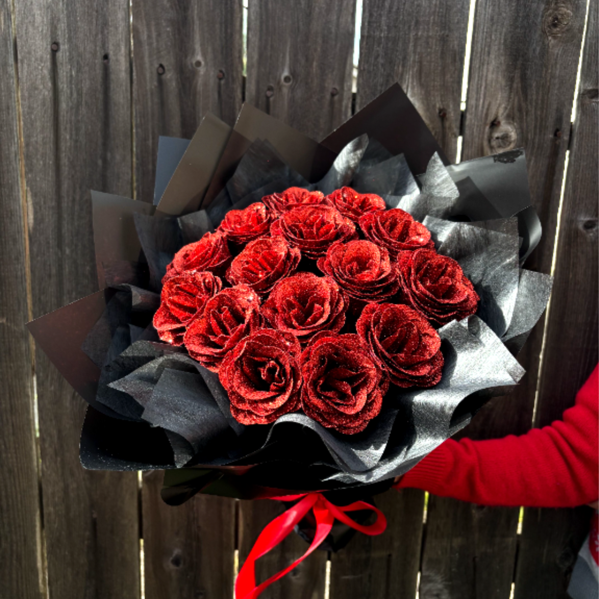 A bouquet of dazzling red roses, each petal shimmering with glitter, wrapped