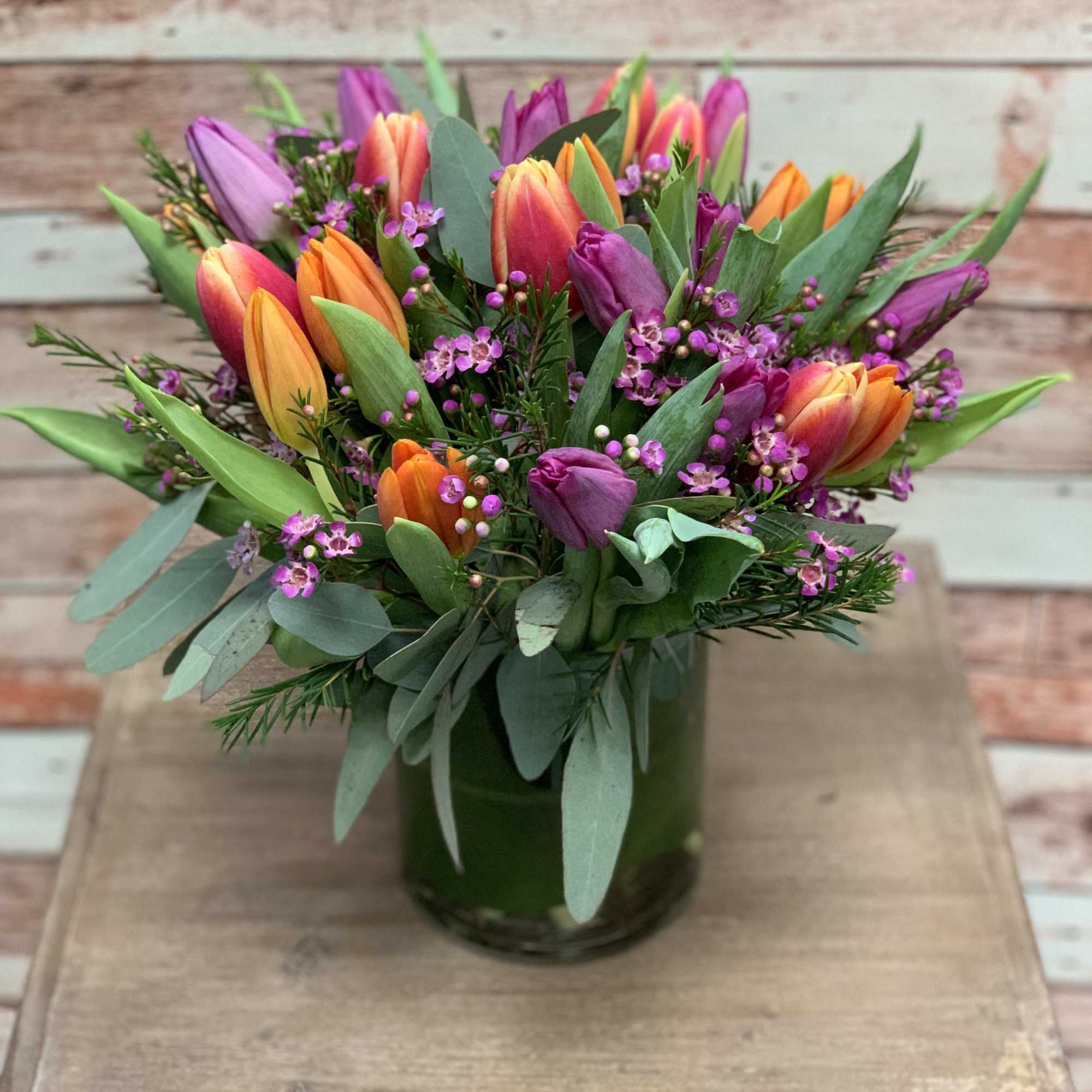 Colorful tulip bouquet in a green glass vase