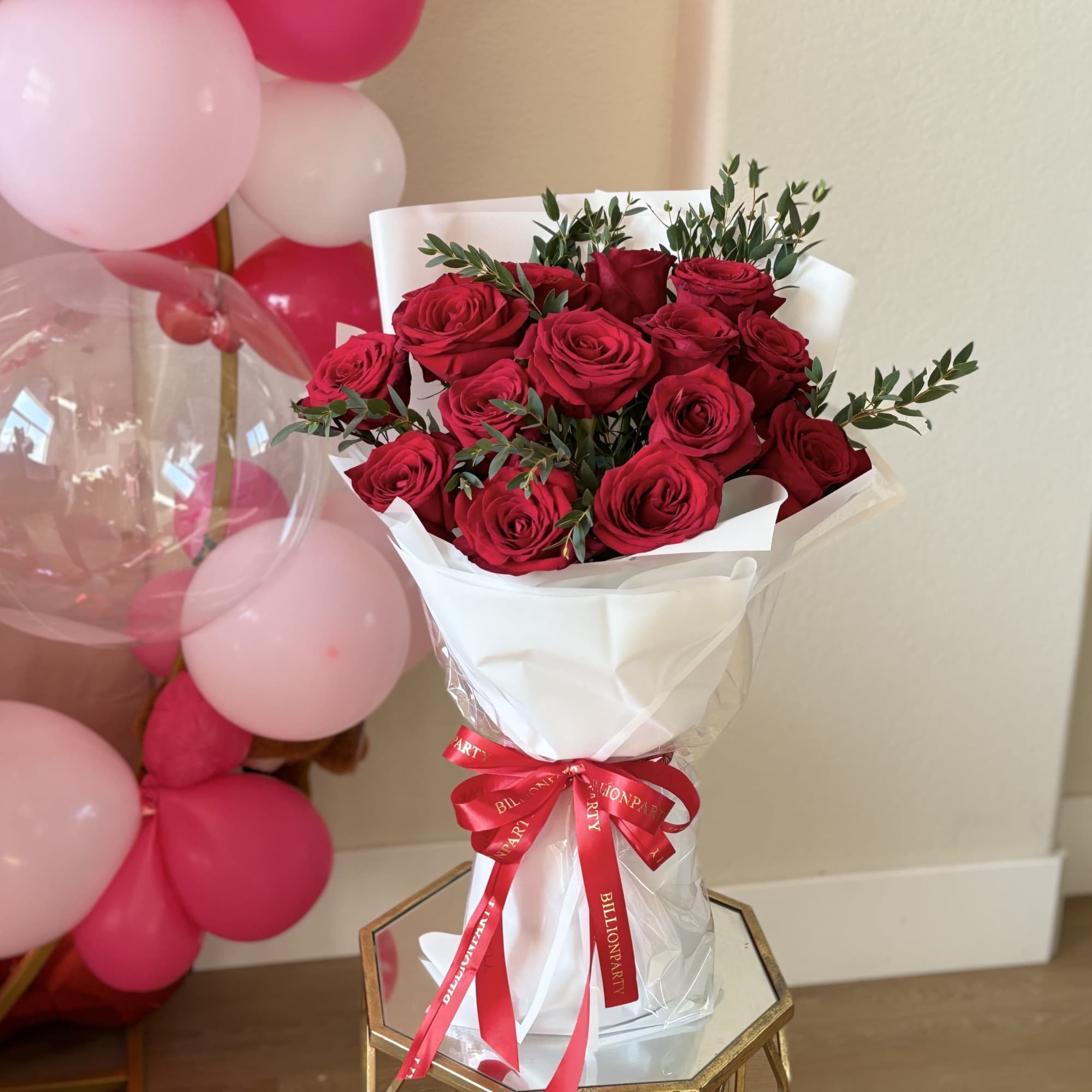 Bouquet of red roses wrapped in white paper with a red ribbon