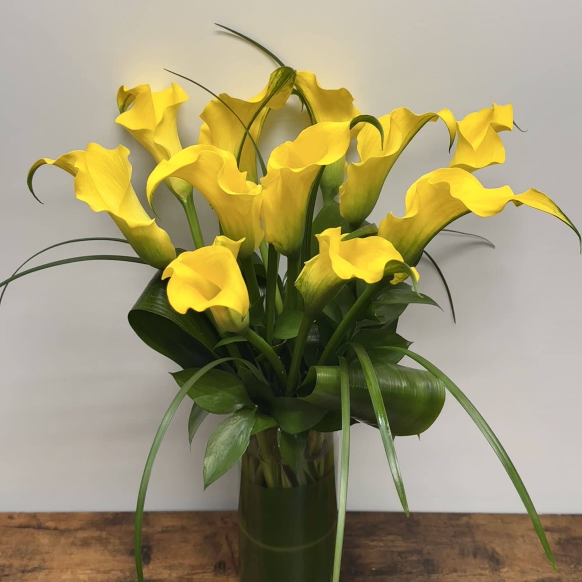 Yellow calla lilies arranged in a clear glass vase