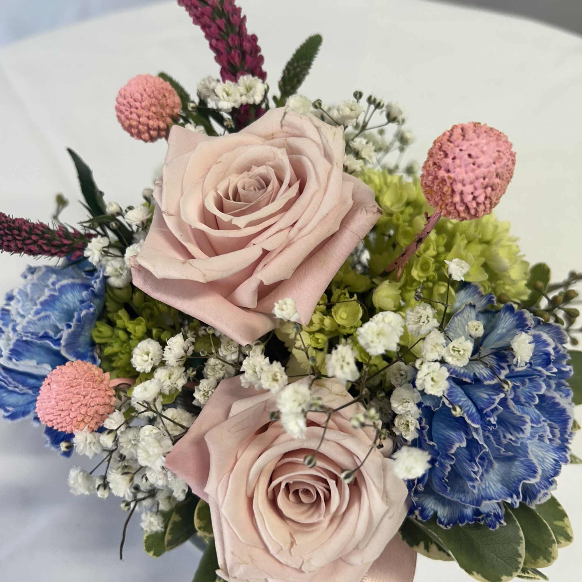 Bouquet of pale pink roses with blue and pink accent flowers