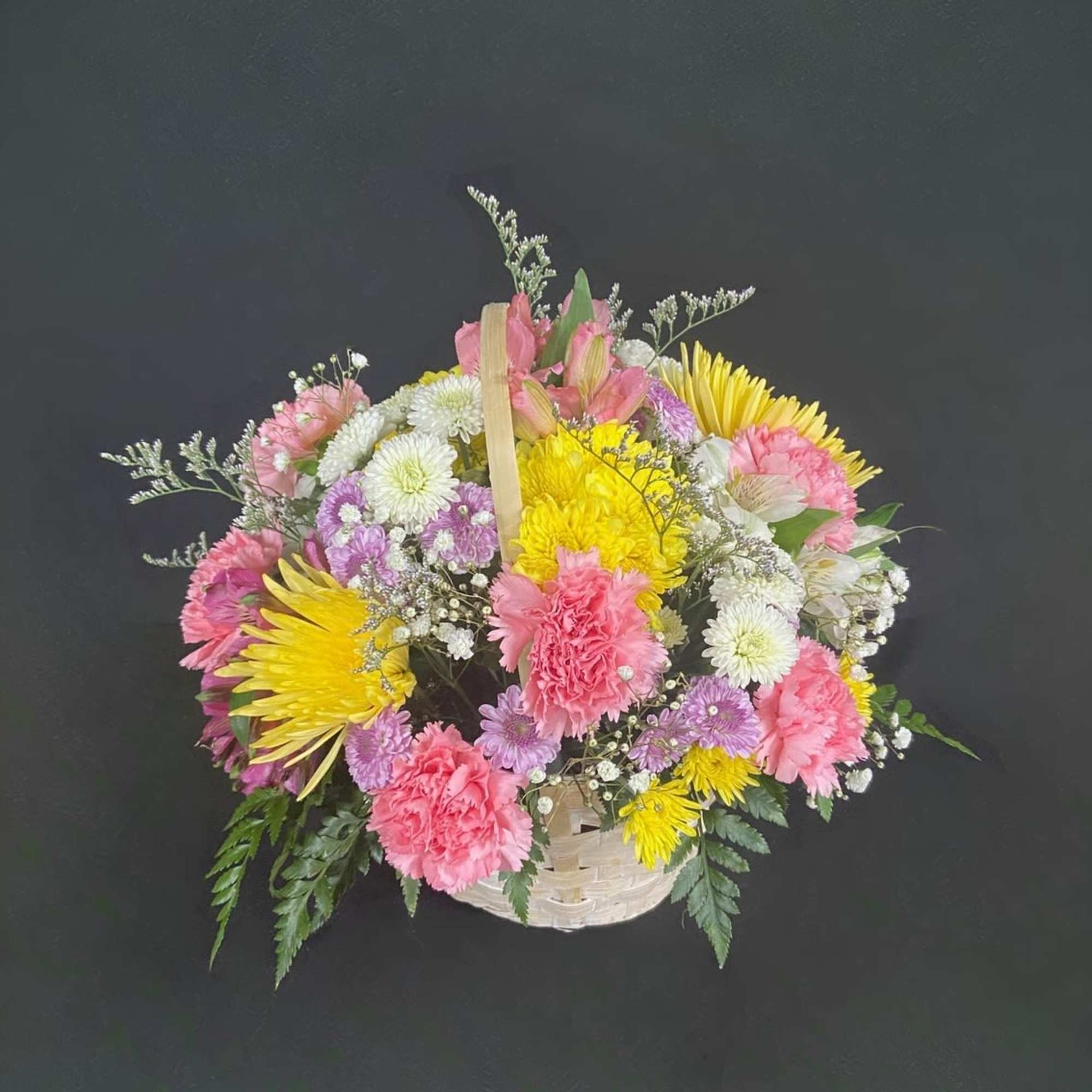 A basket of bright, colorful flowers to pick up anyone's spirits. Includes