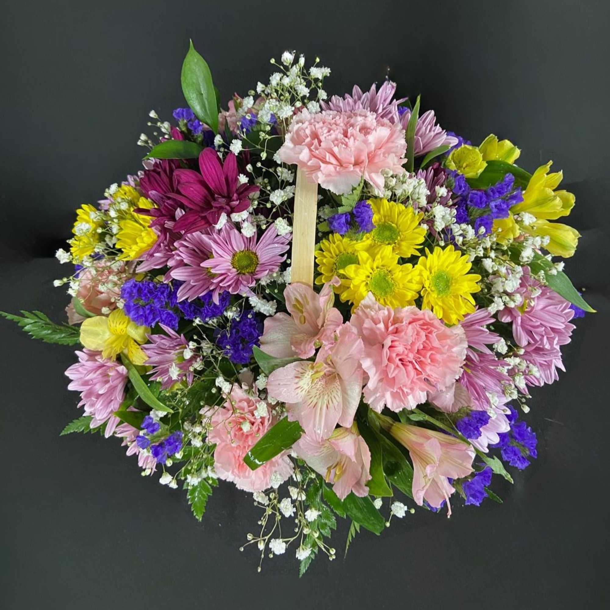 A basket of bright, colorful flowers to pick up anyone's spirits. Includes