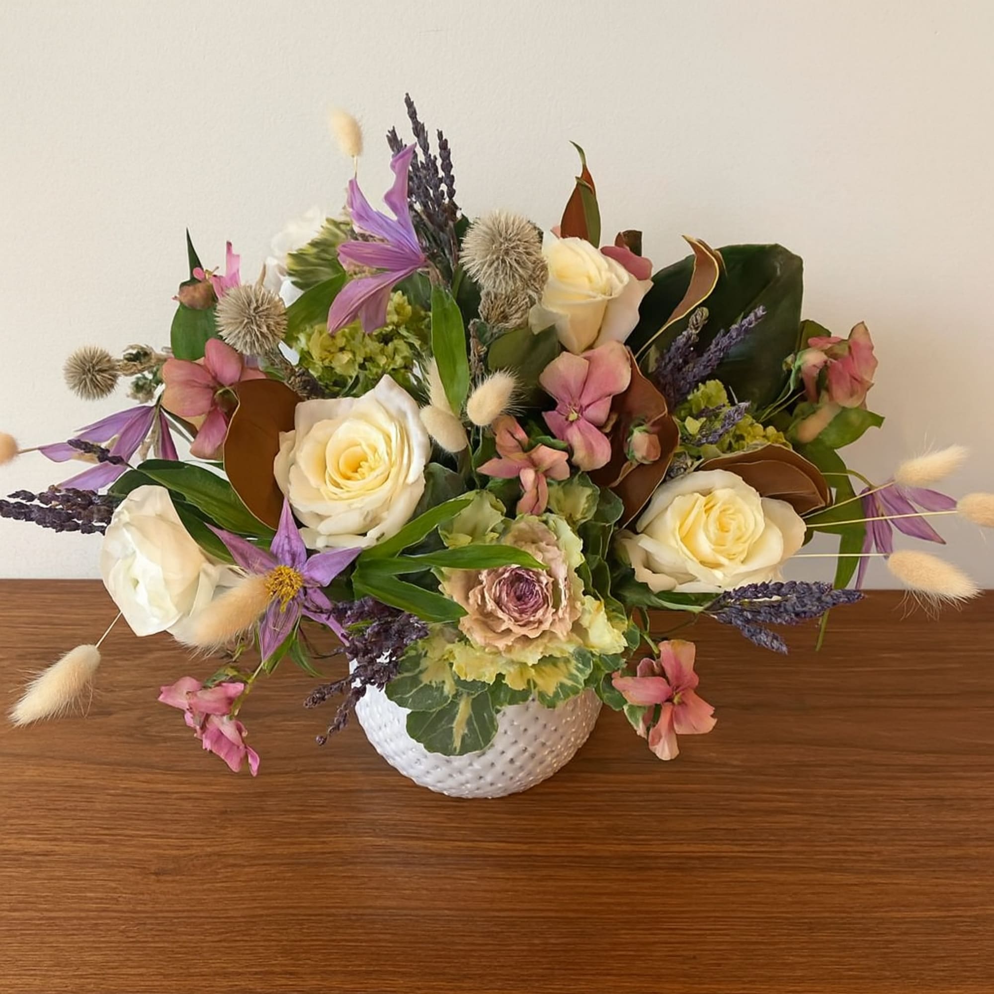 A joyful blend of creamy white roses, lavender clematis, and blush pink