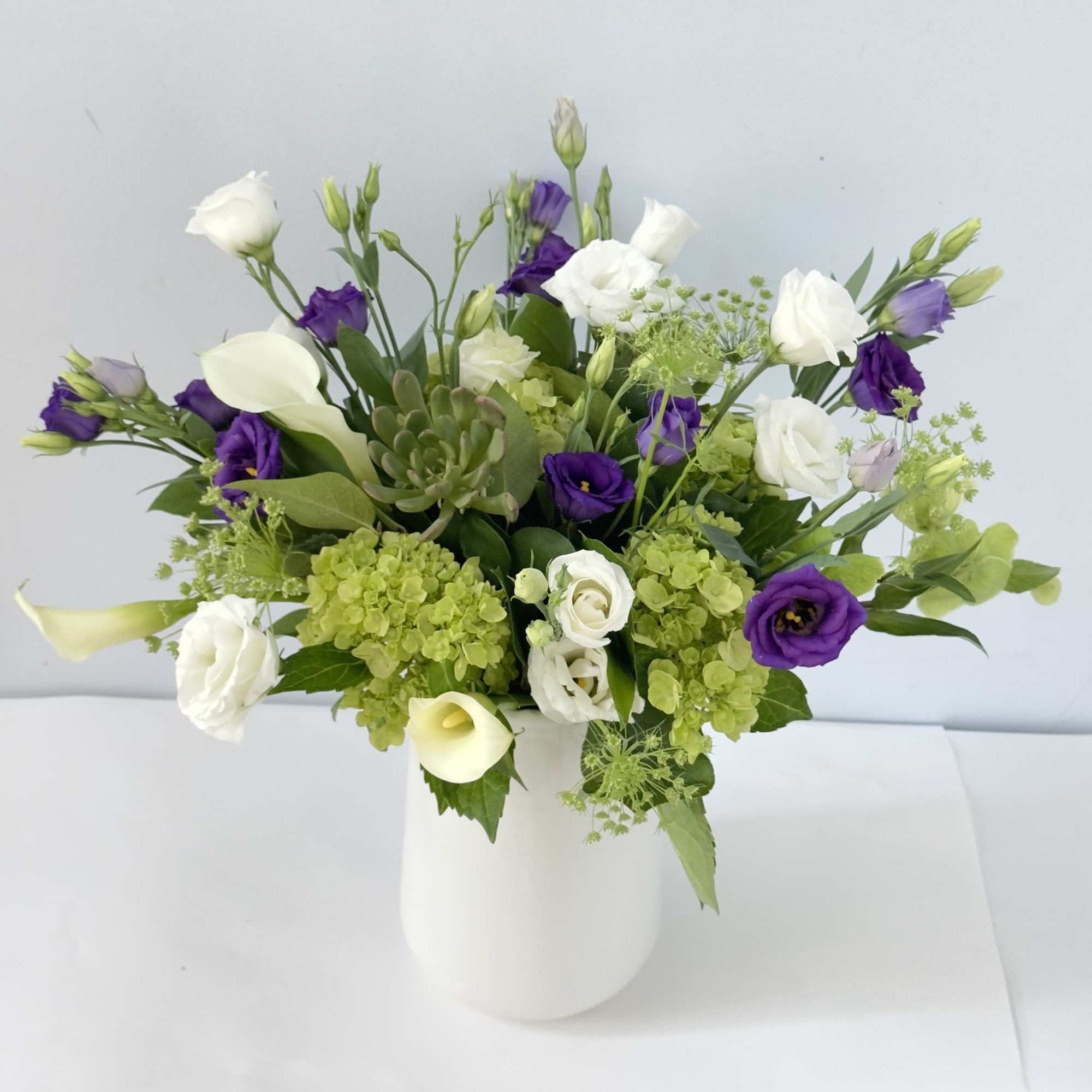 This arrangement is presented in 4"w*8" tall white ceramic vase. It features