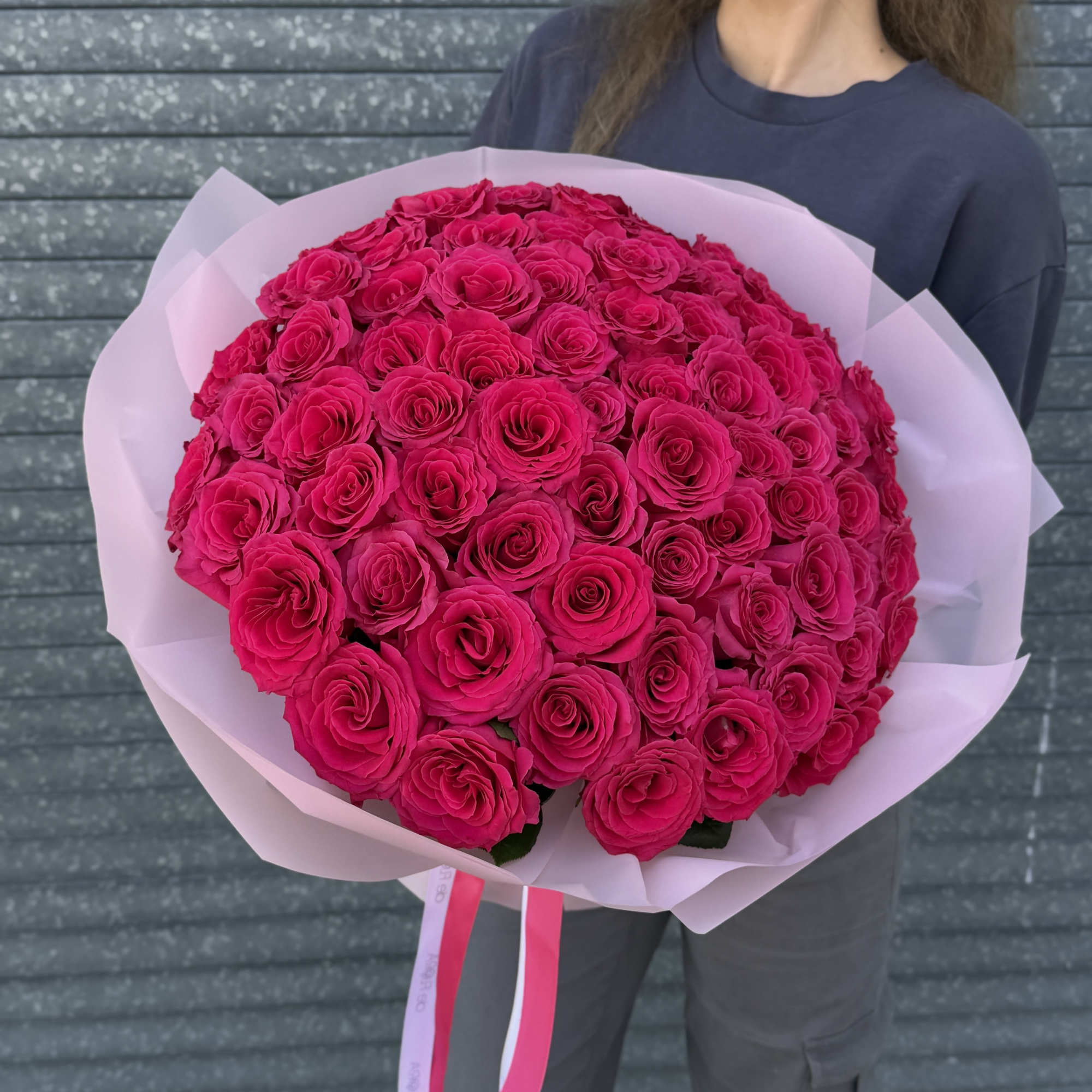Large bouquet of hot pink roses wrapped in pale pink paper