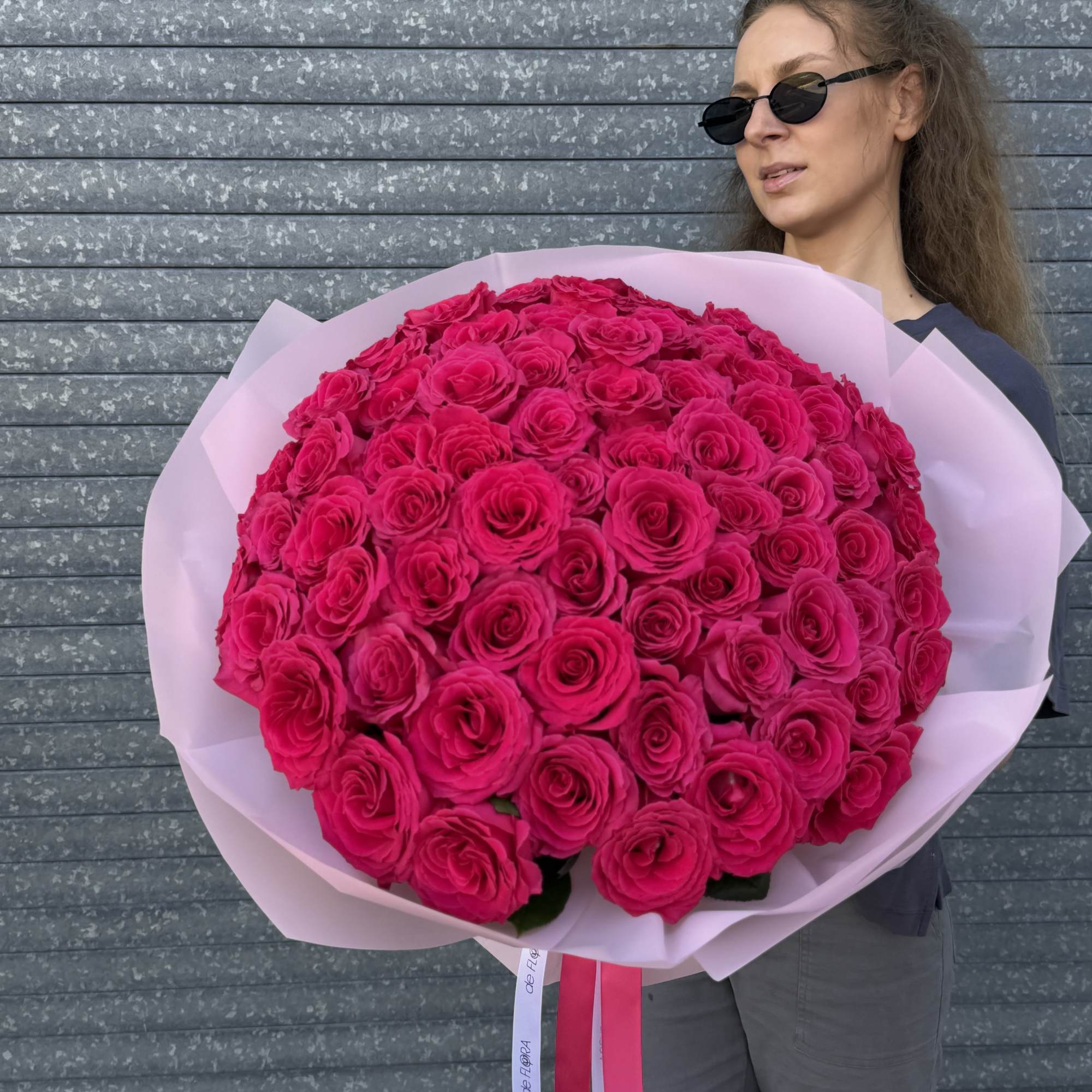 Large bouquet of hot pink roses wrapped in pale pink paper