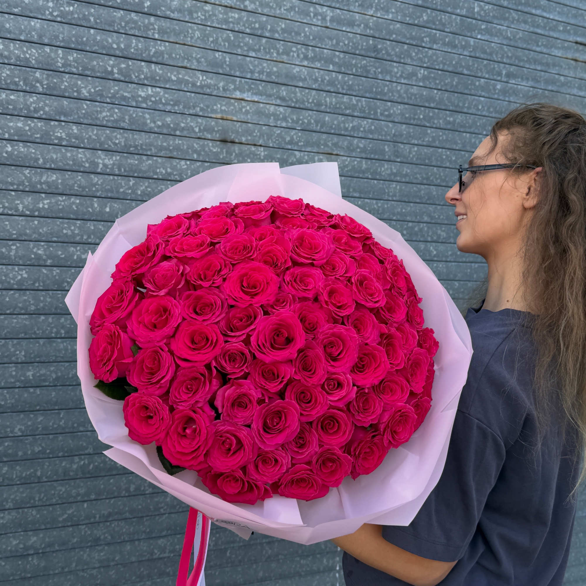 Large bouquet of hot pink roses wrapped in pale pink paper