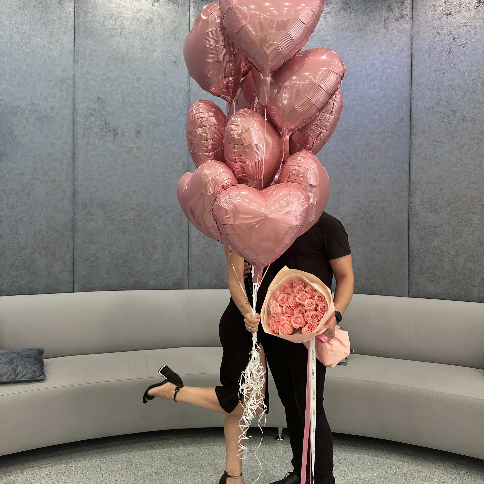 Pink heart balloons with a bouquet of pink roses