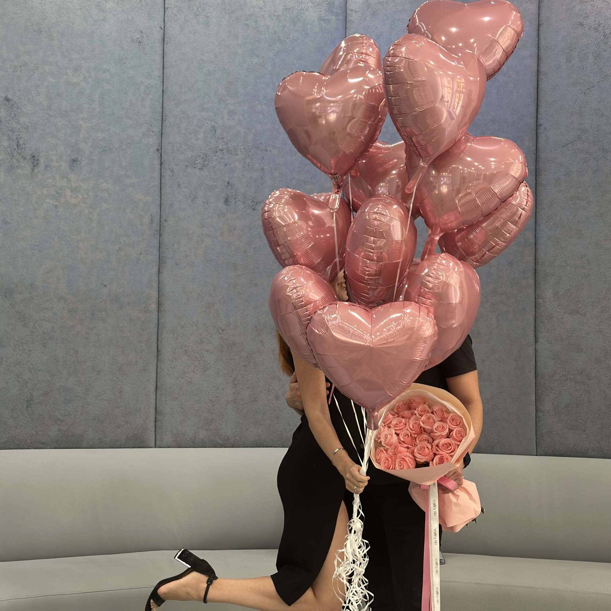 Pink heart balloons with a bouquet of pink roses