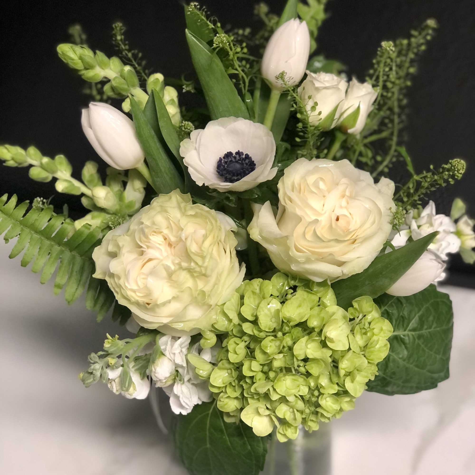 Cream flowers and pale green hydrangea in a glass vase