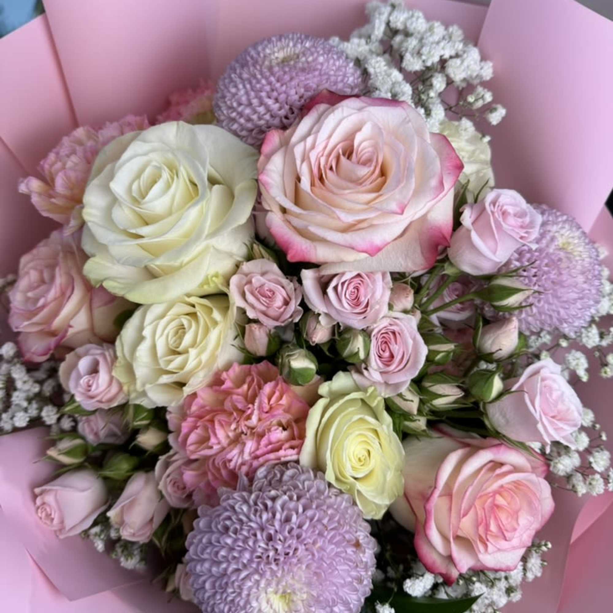 Pink and white rose bouquet with lavender blooms wrapped in pink paper