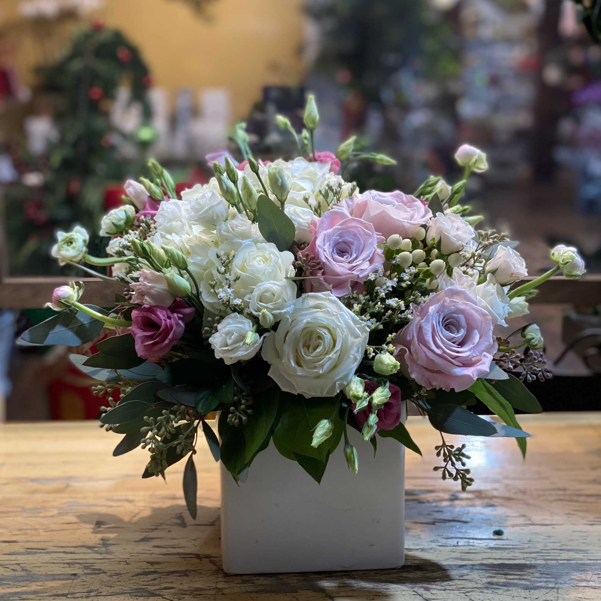 Bouquet of pink and white roses in a white square vase