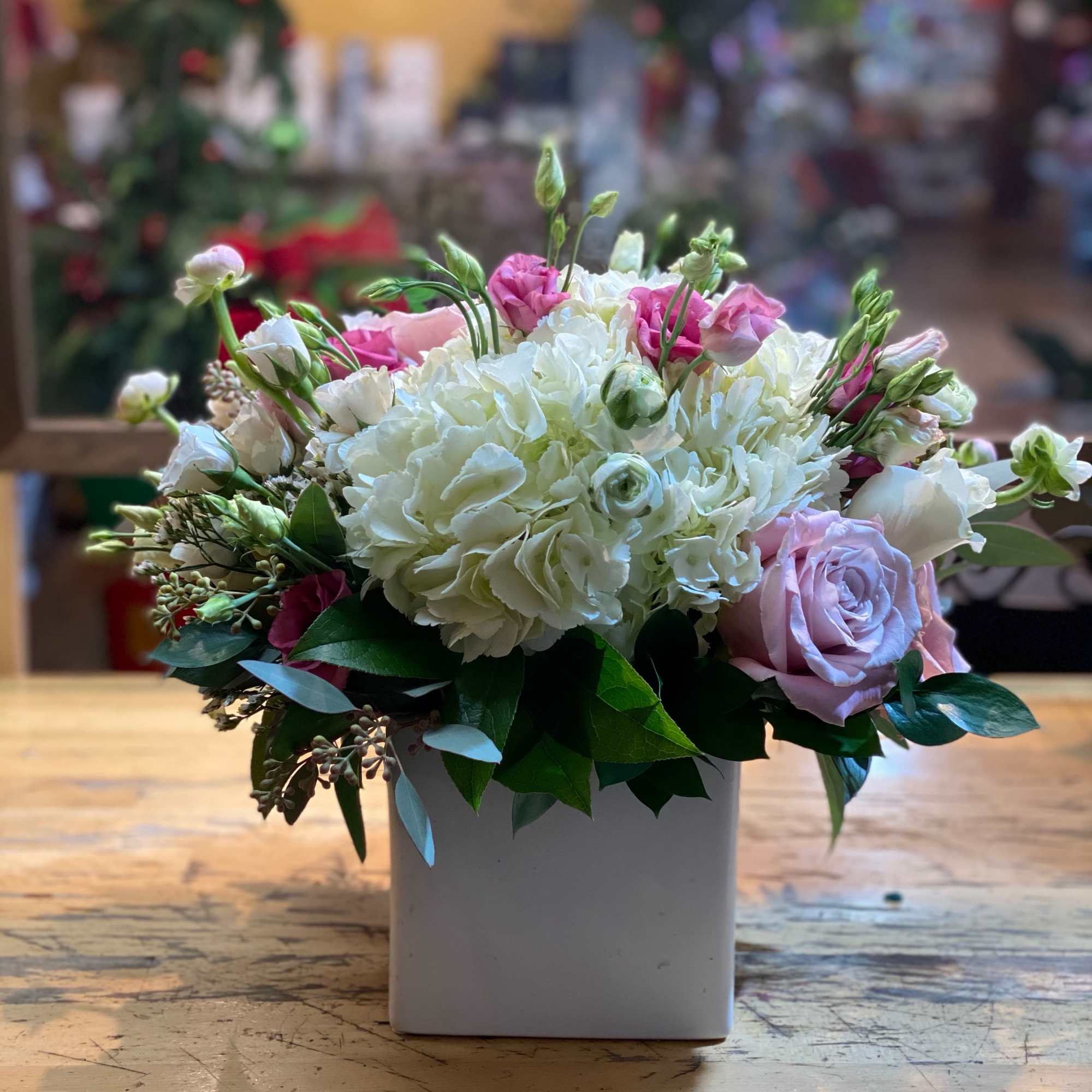 White and pink floral arrangement in a square white vase