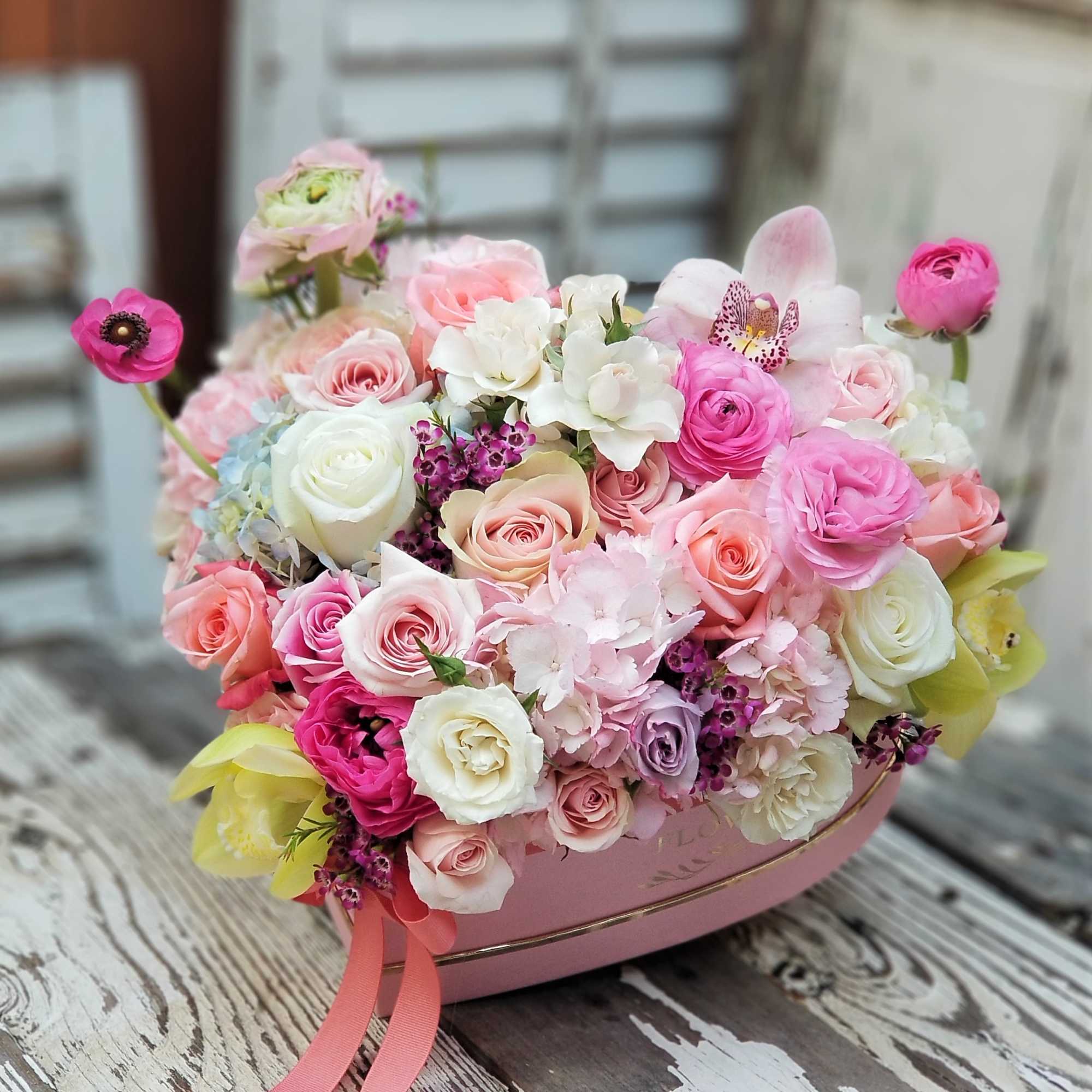Pink and white rose bouquet in a pink heart-shaped box