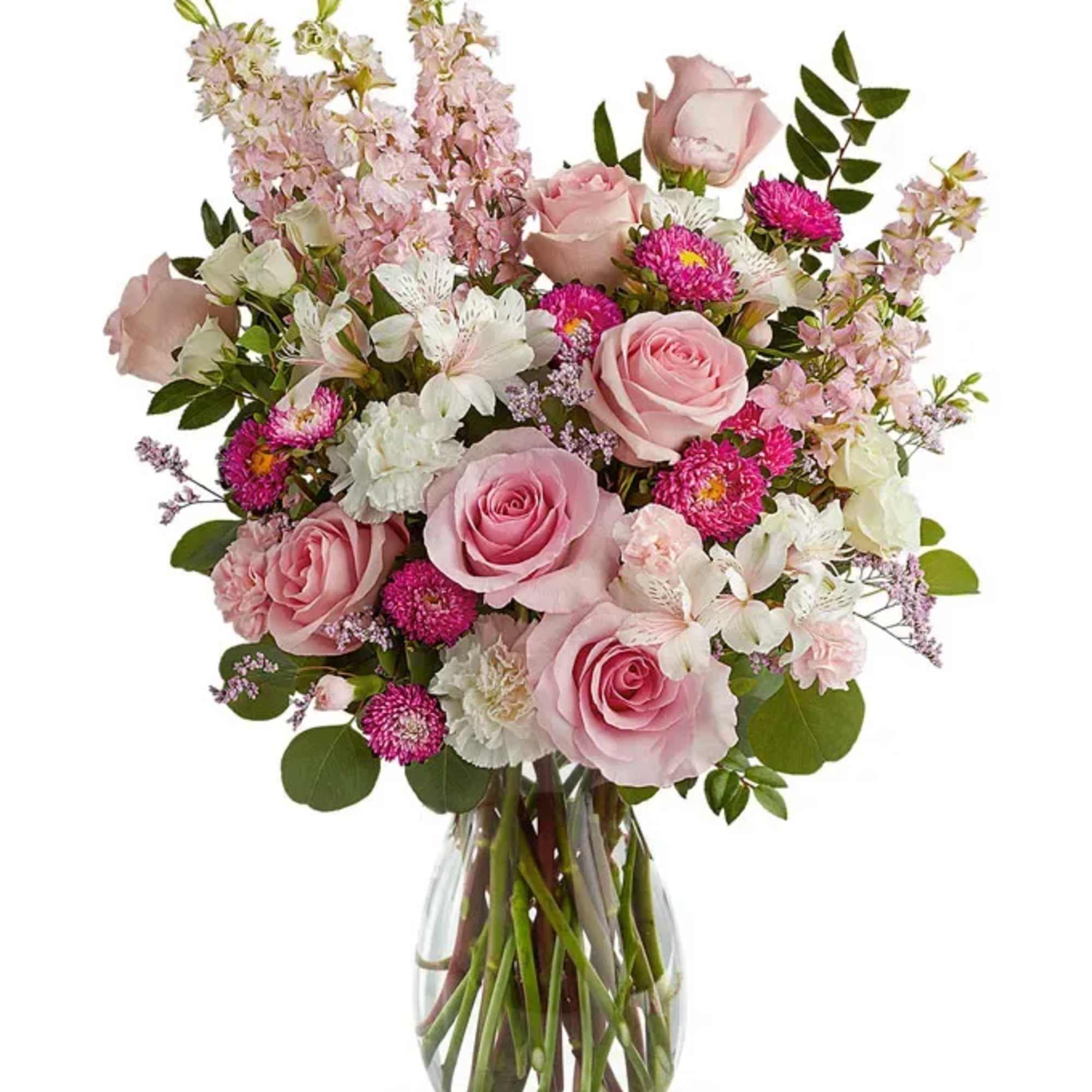 Pink roses and mixed flowers arranged in a clear glass vase