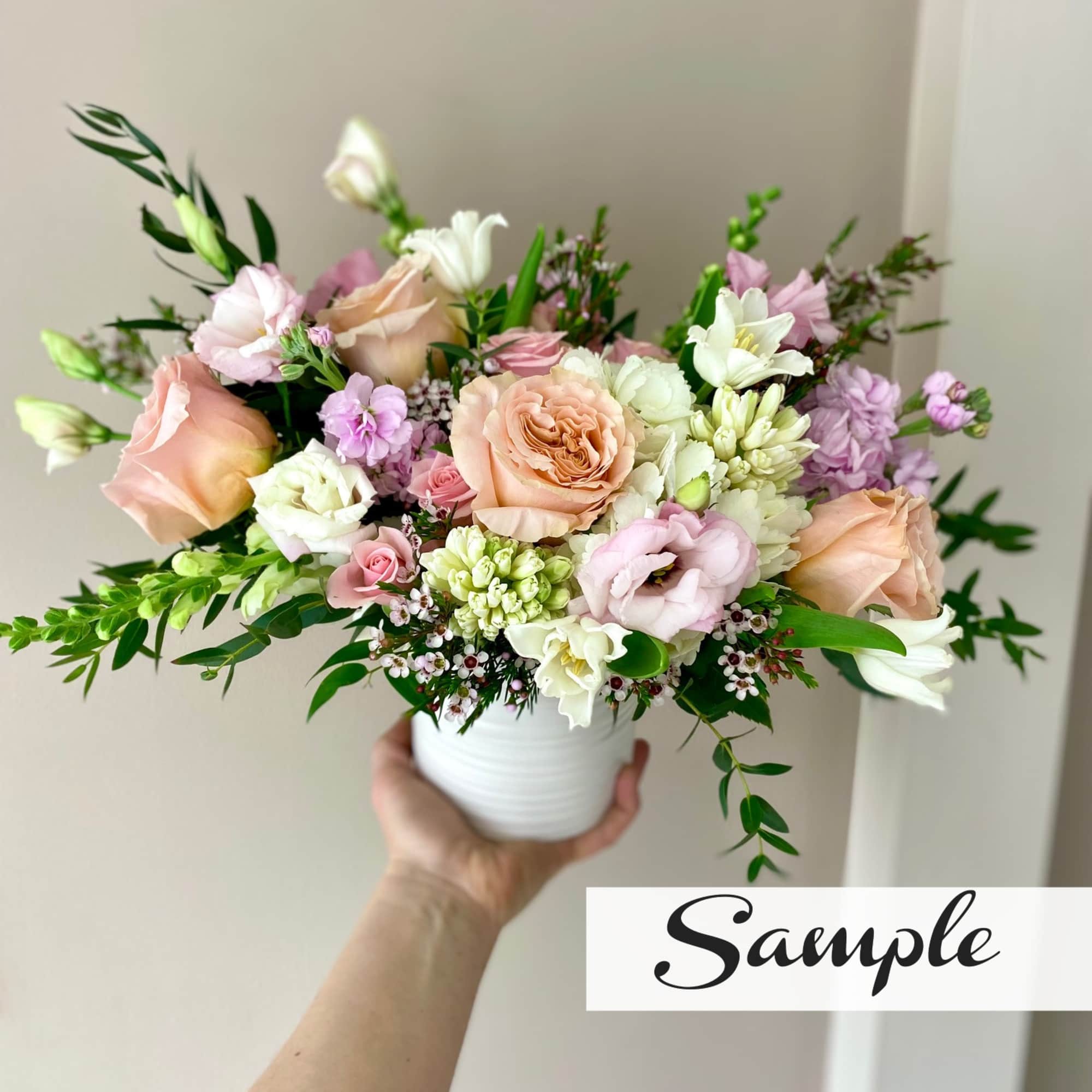 Pastel bouquet of roses and lisianthus in a white vase