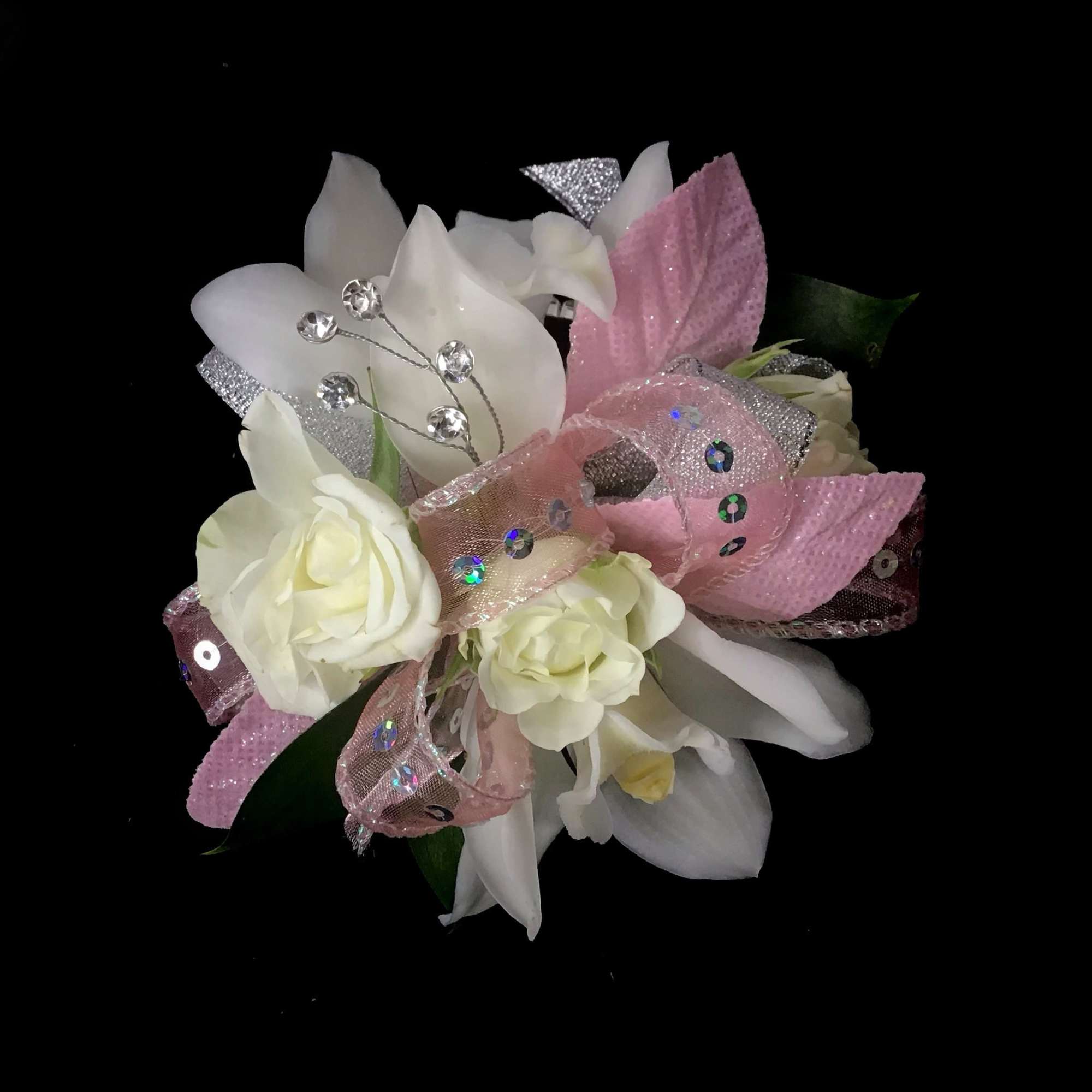 White roses and lilies with pink ribbon on a black background