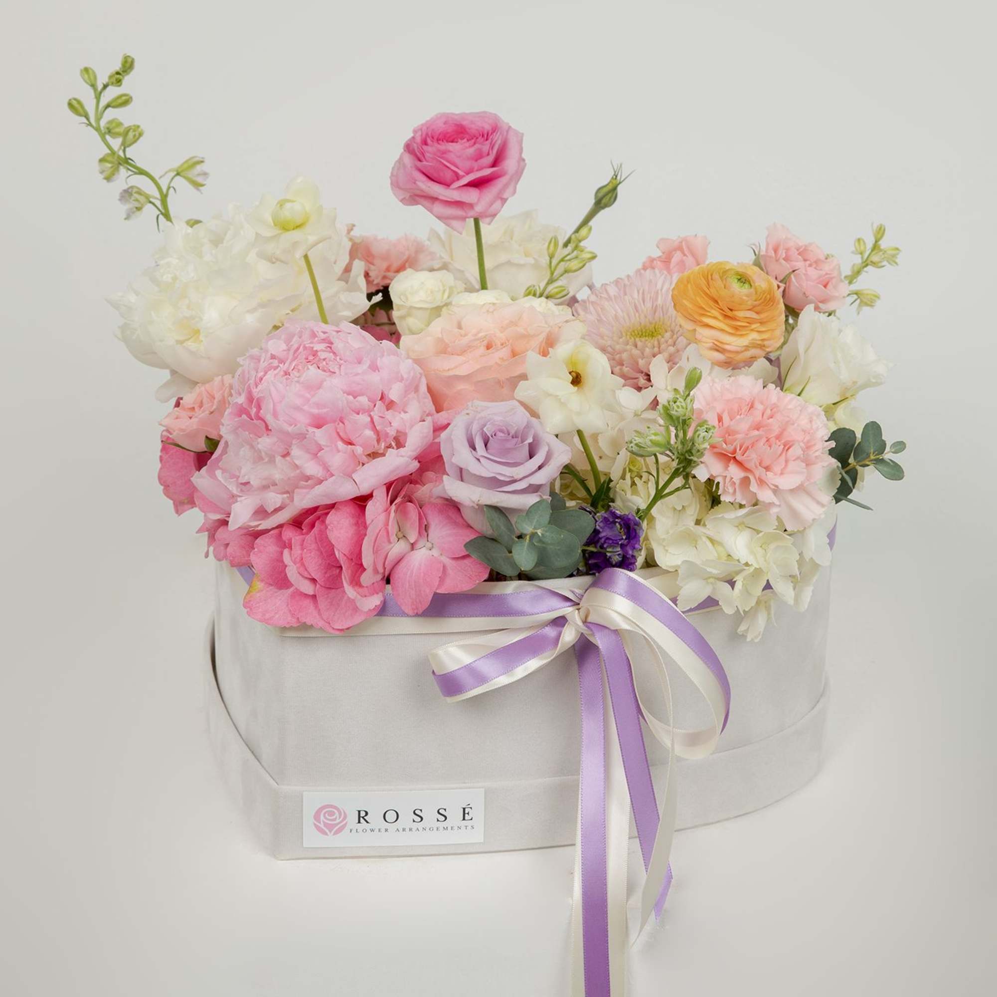 A garden-style mix flower arrangement in a velvet heart box.
Soft pastel blooms