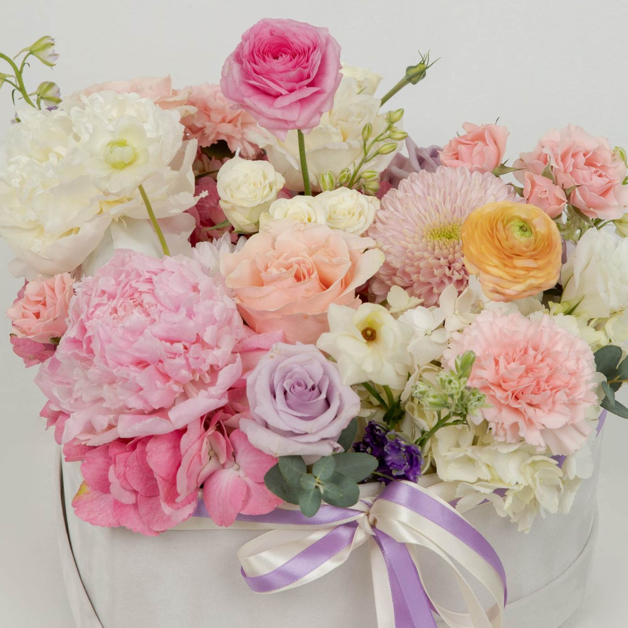 A garden-style mix flower arrangement in a velvet heart box.
Soft pastel blooms