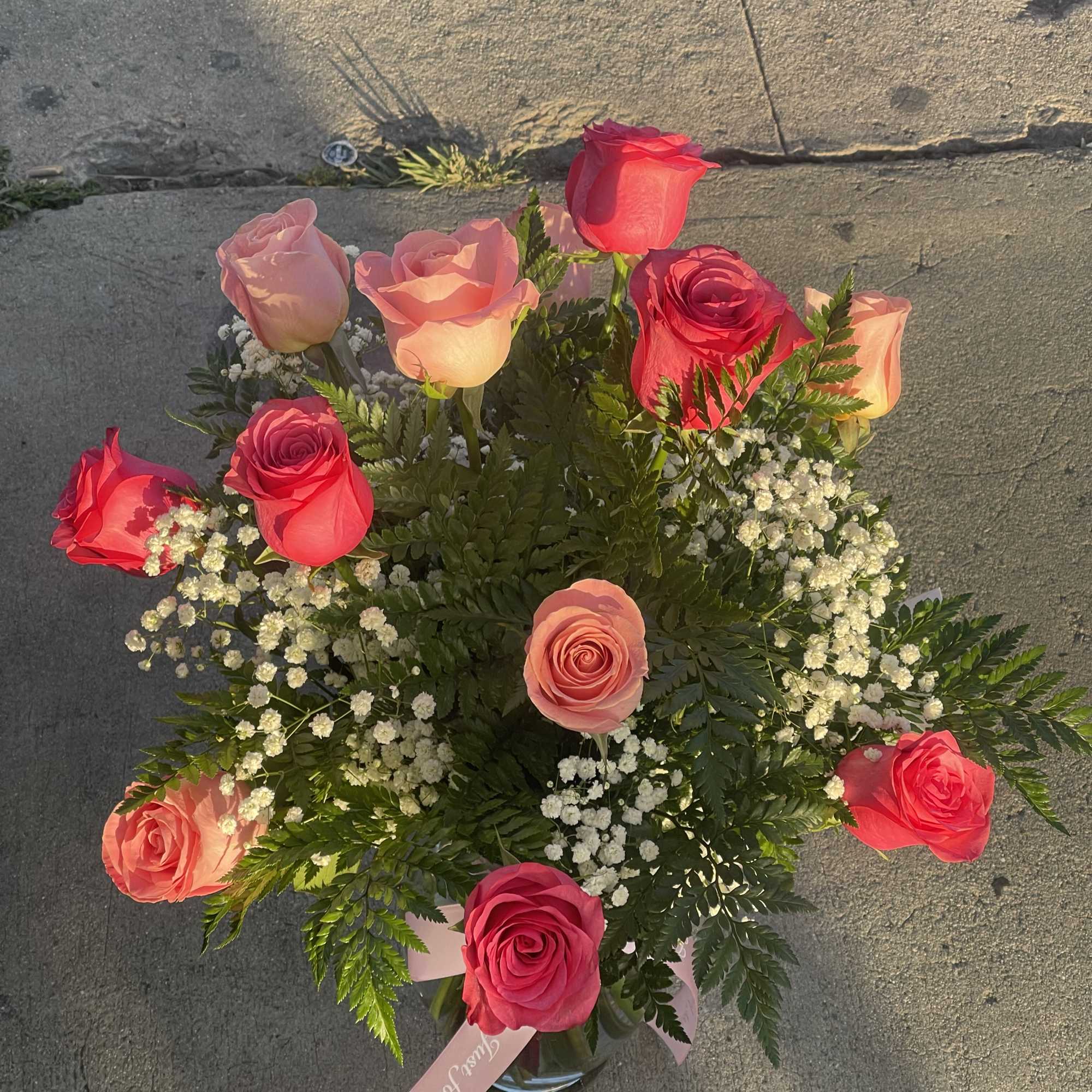 Bouquet of pink and red roses with baby's breath in a glass vase