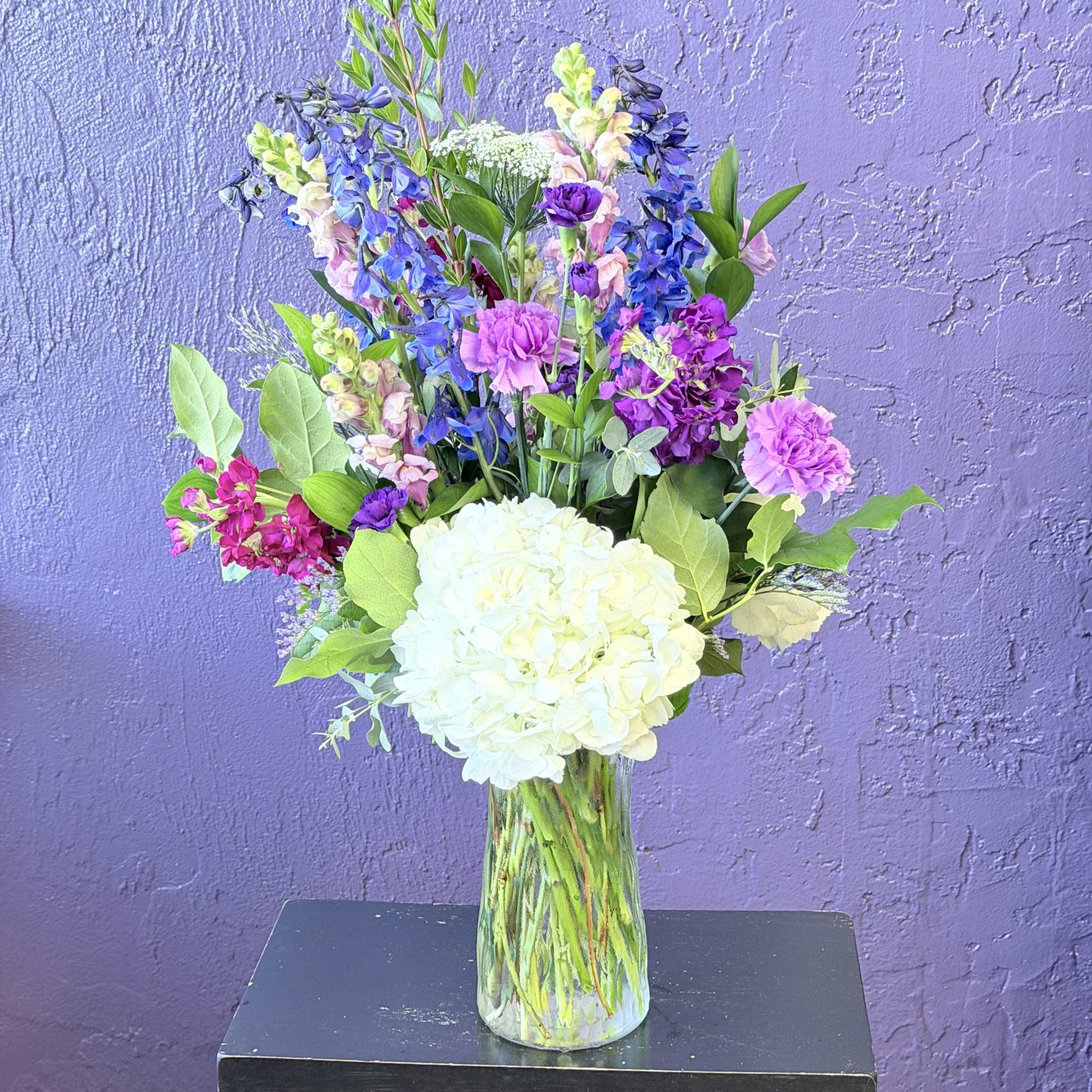 Tall spires of pink and lavender stock and snapdragons rise above soft