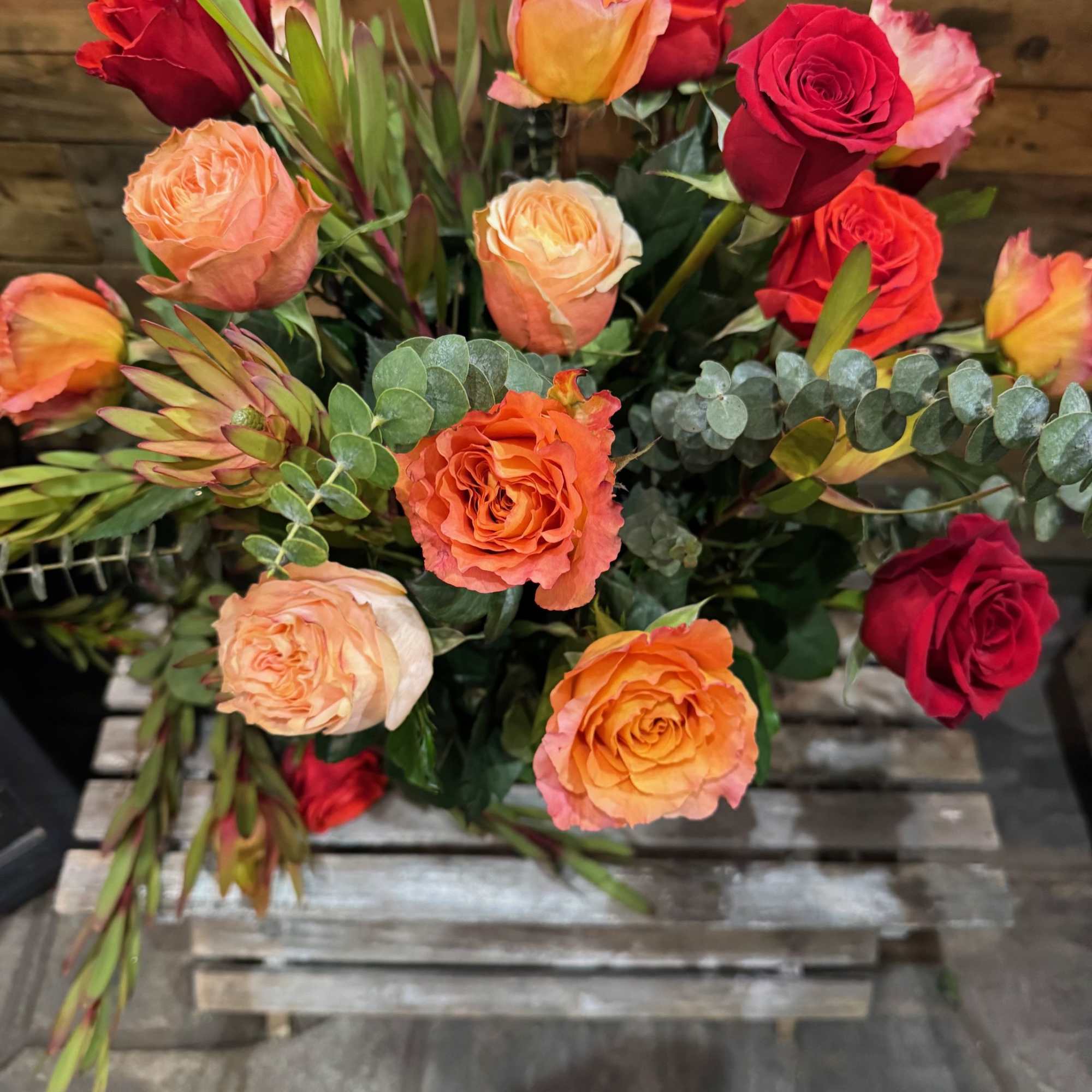 Bouquet of red and peach roses with eucalyptus