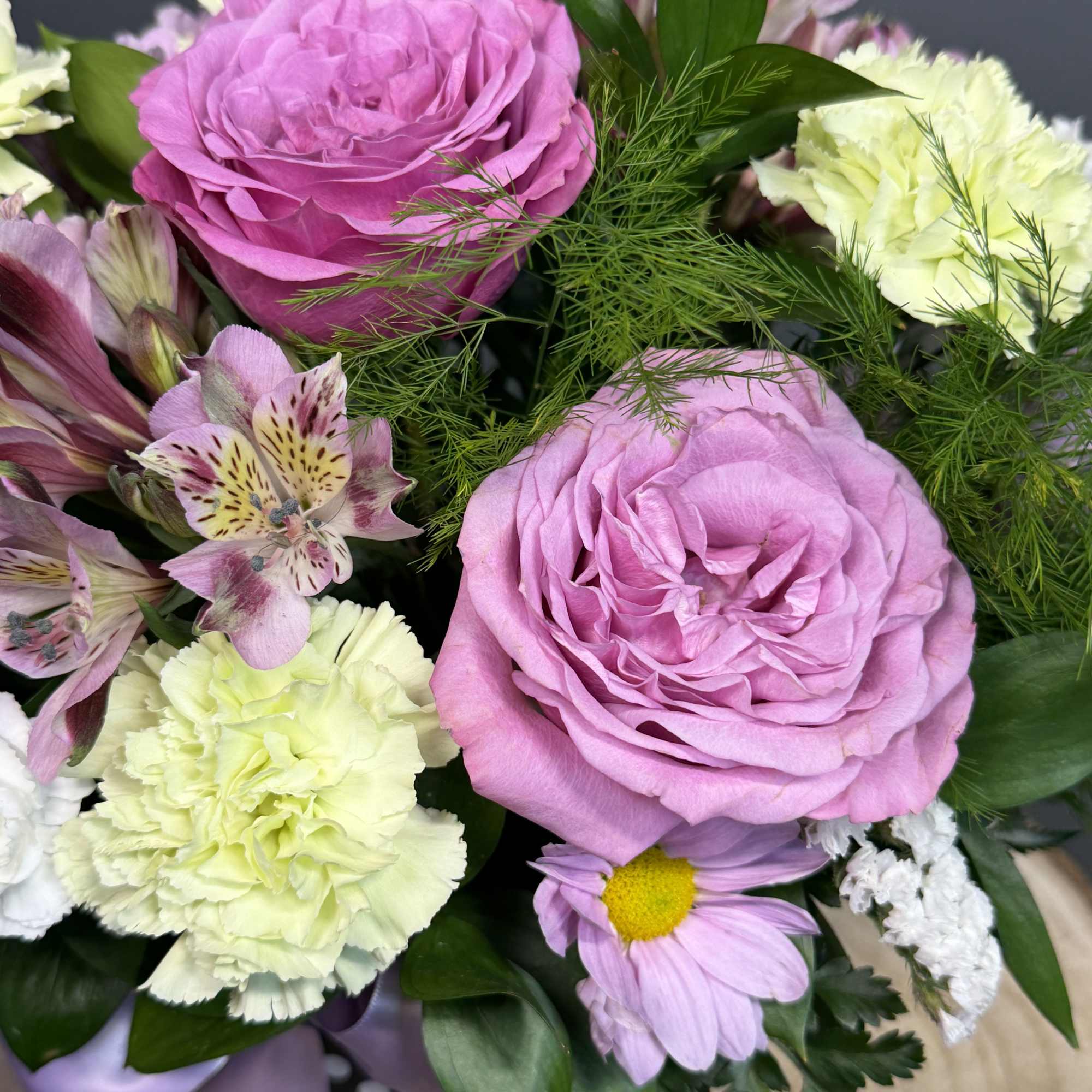 A graceful blend of roses, alstroemeria, and carnations in gentle hues, accented