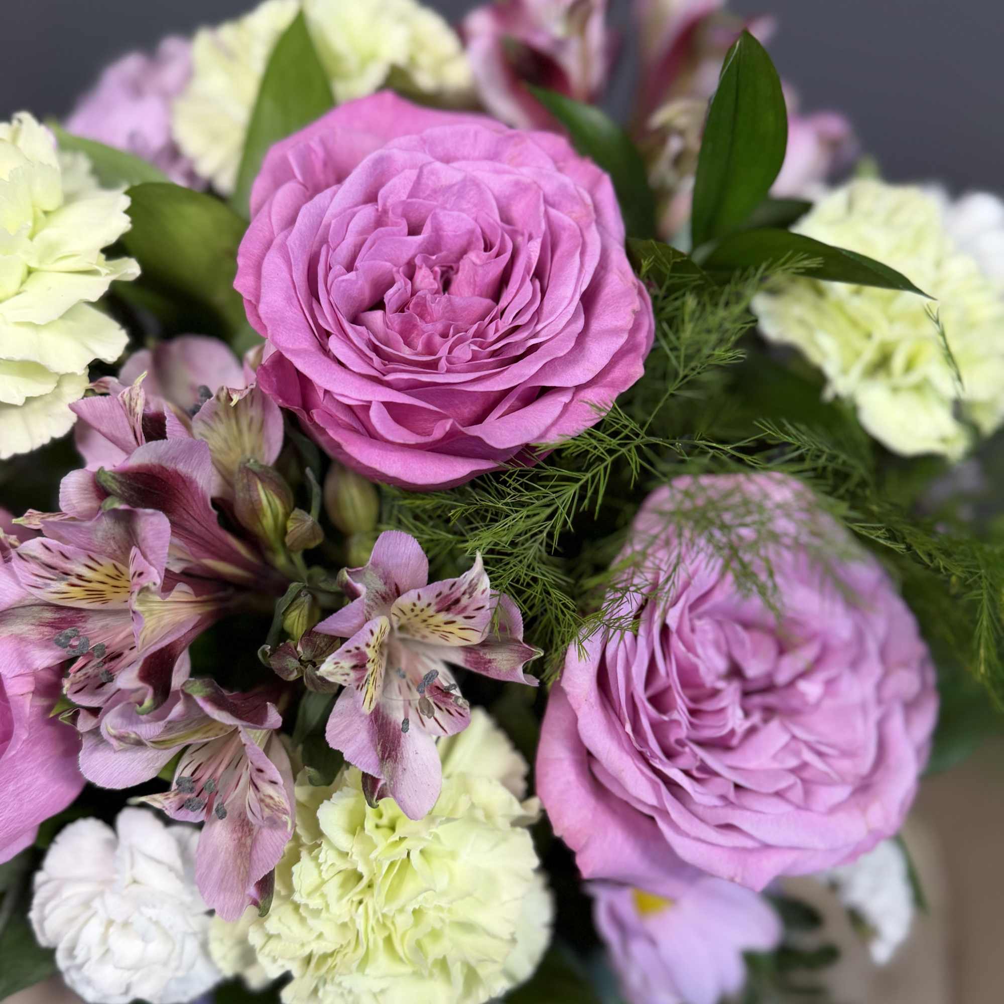A graceful blend of roses, alstroemeria, and carnations in gentle hues, accented