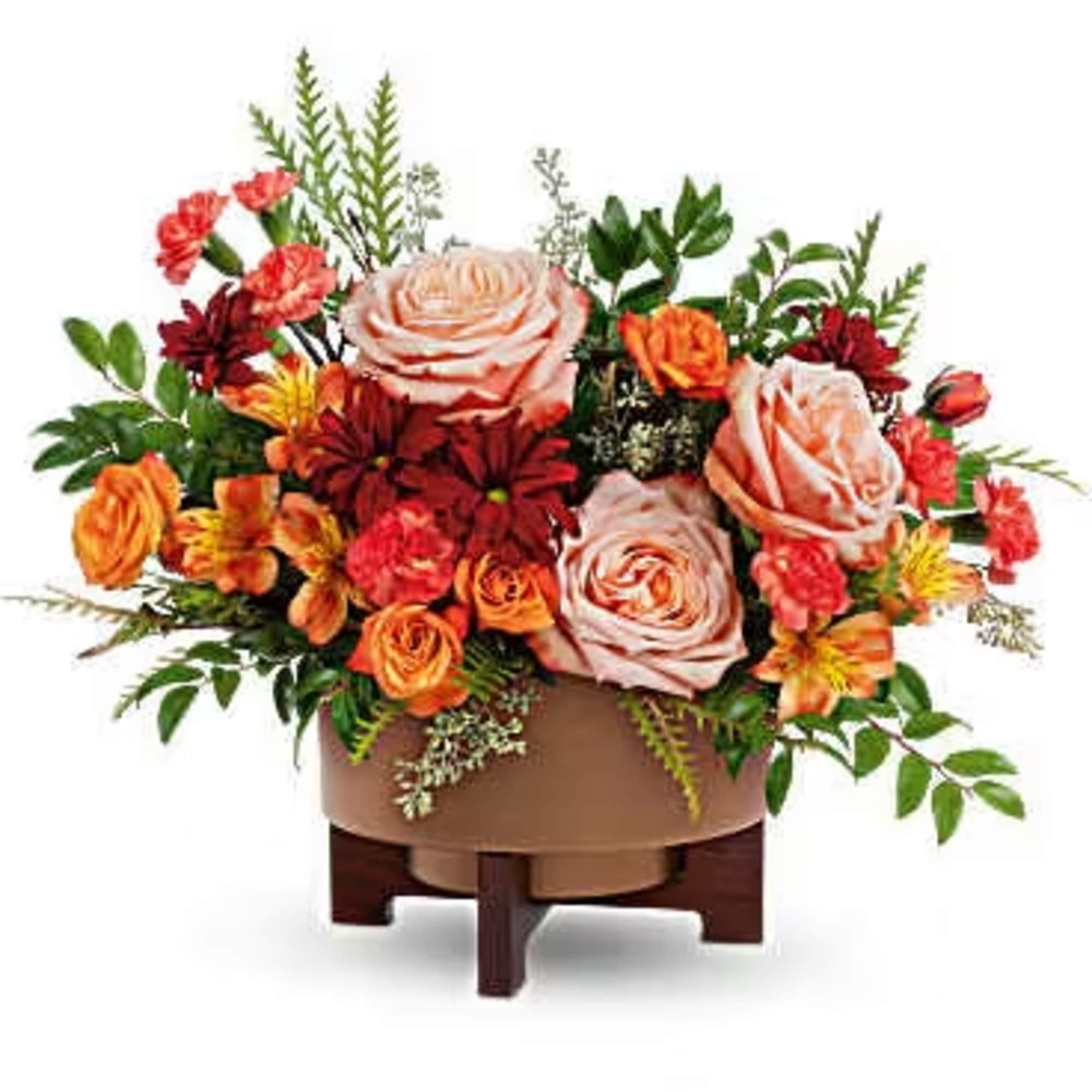 Arrangement of peach roses, orange flowers, and red blooms in a low container