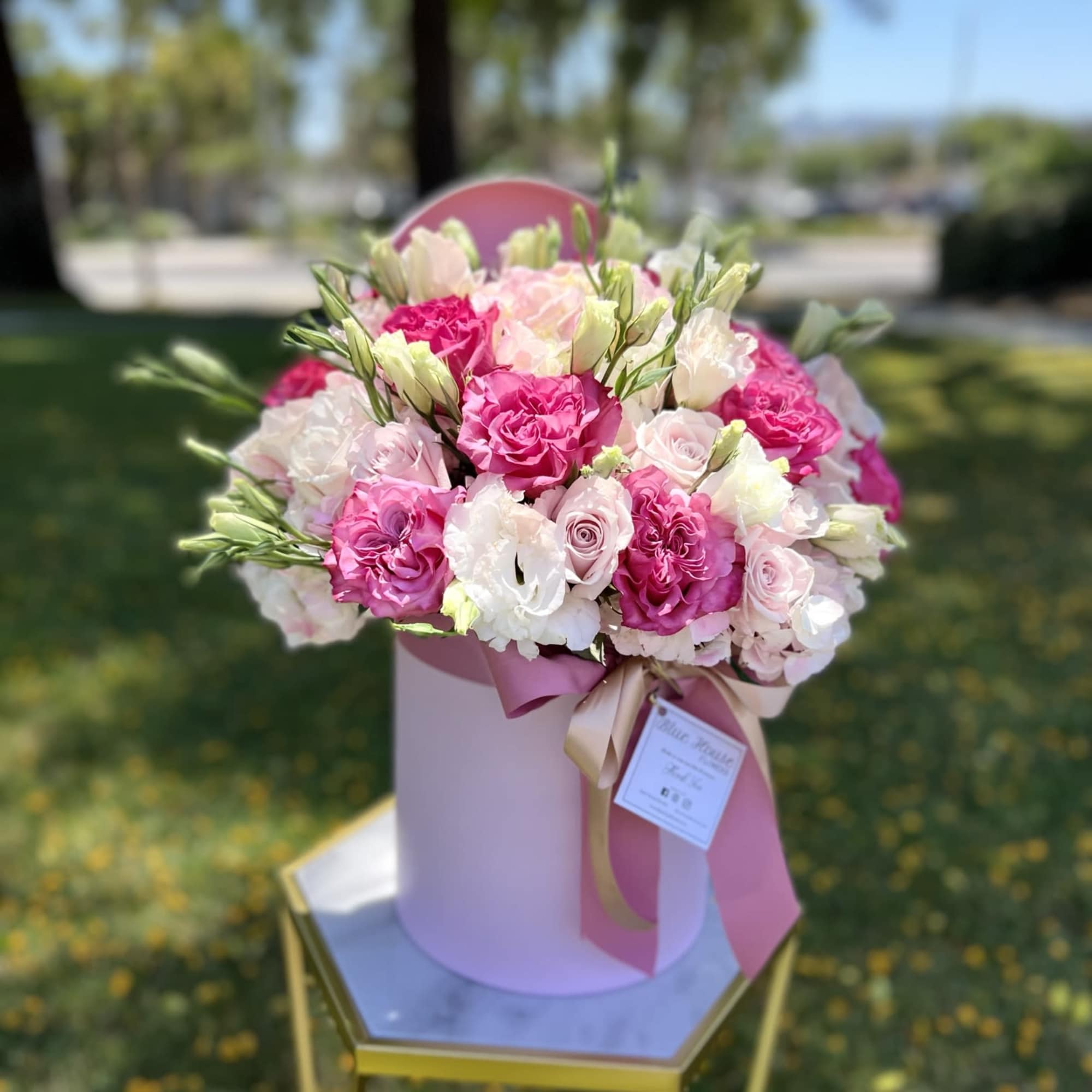 Pink and white rose bouquet in a pastel hat box with ribbon