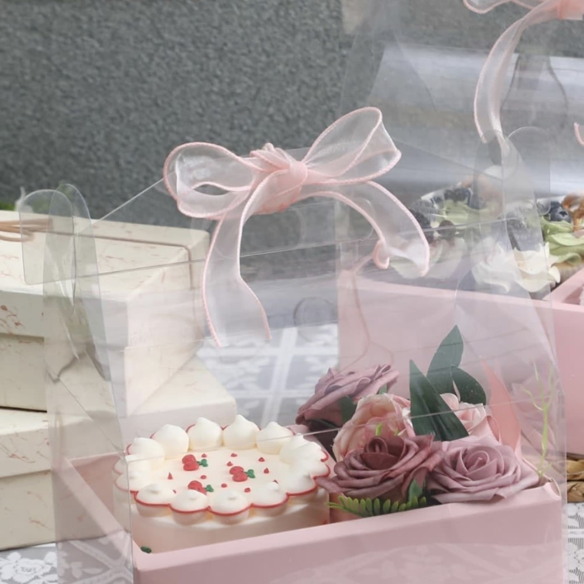 A petite pink cake paired with a compact cluster of blush roses