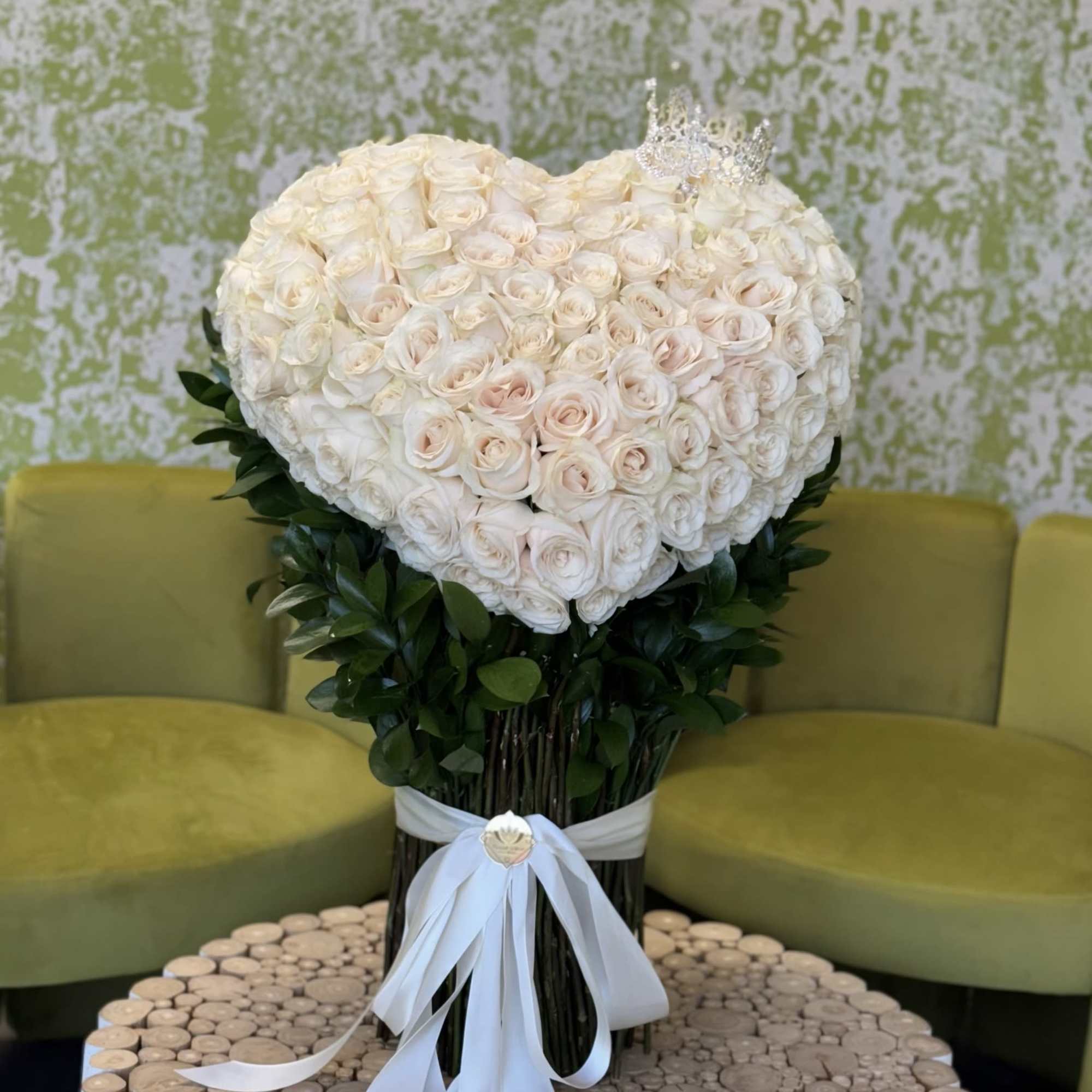 Heart-shaped bouquet of white roses with a white ribbon