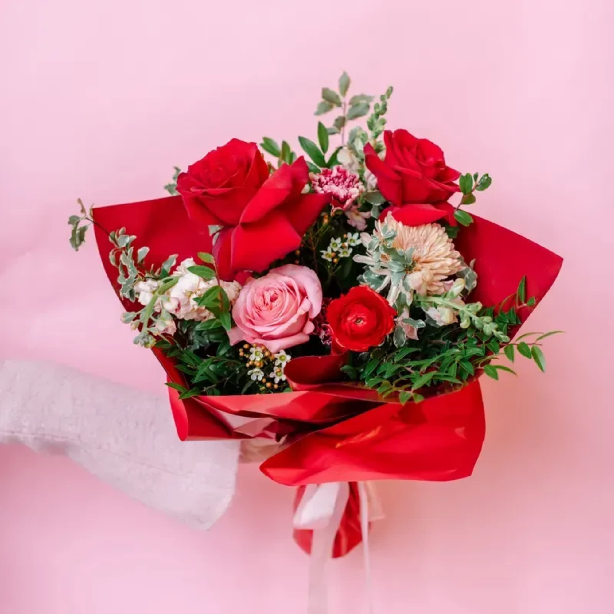 Bouquet of red and pink roses wrapped in red paper