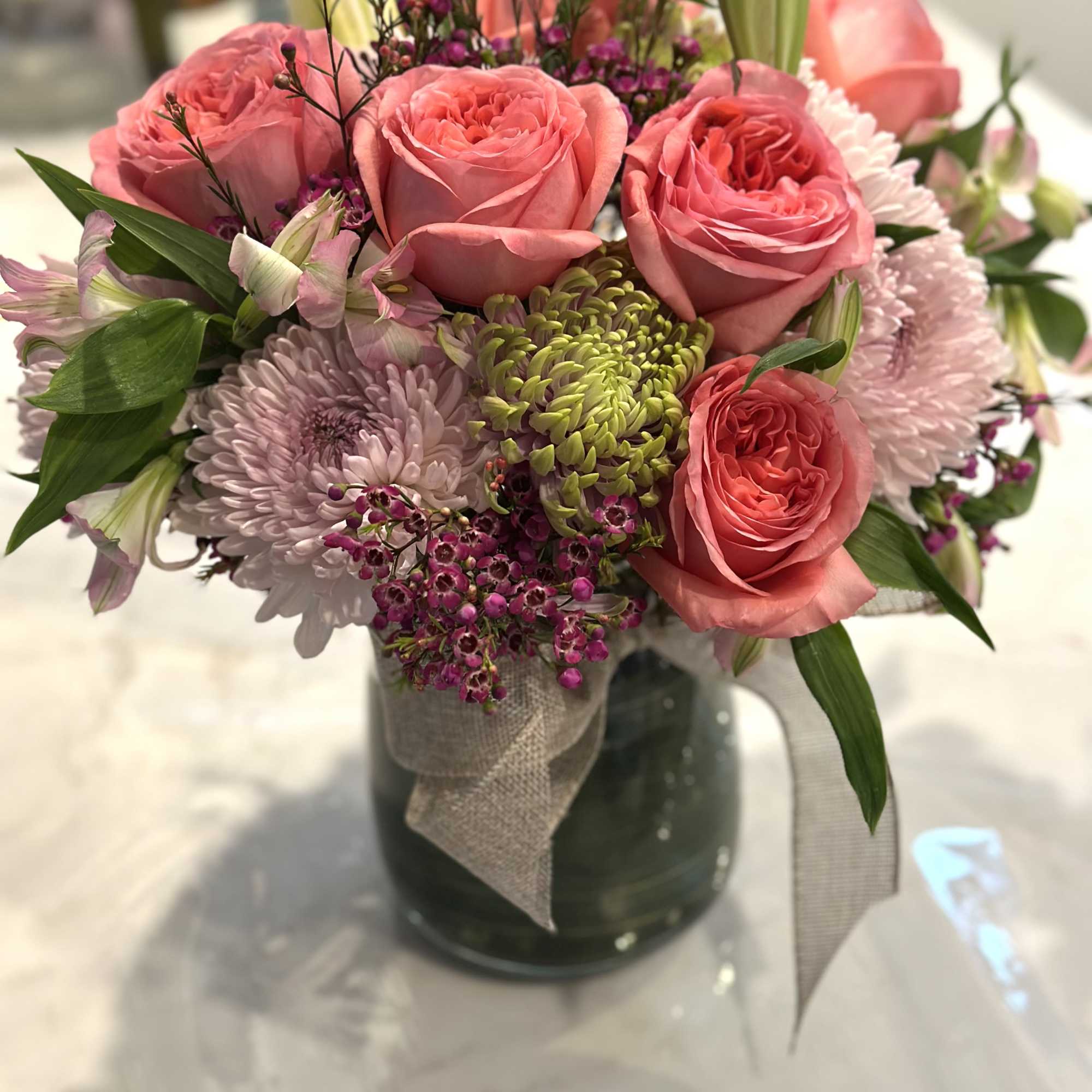 Pink roses and chrysanthemums arranged in a glass vase