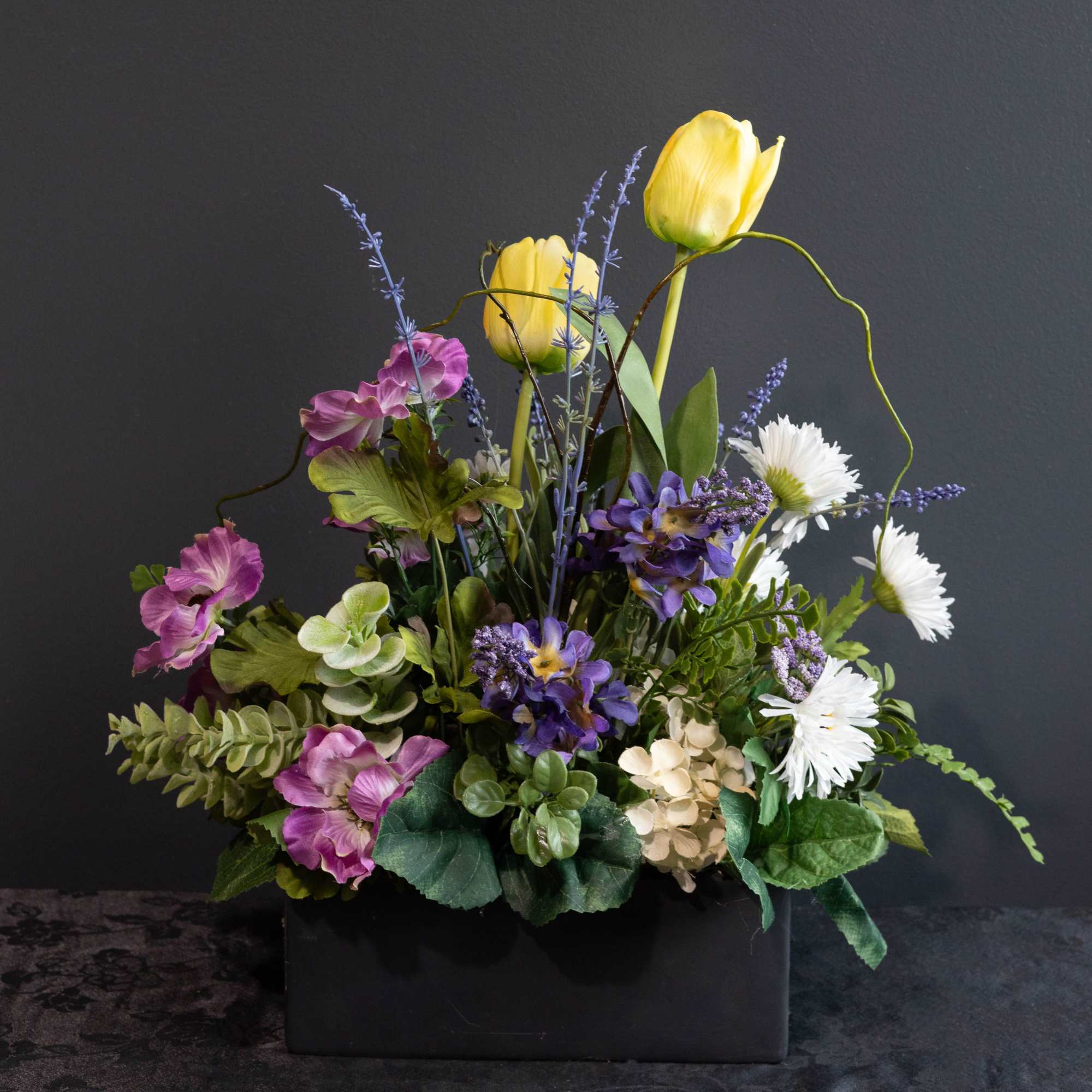 A beautiful silk-faux flower arrangement that will be everlasting for the recipient.