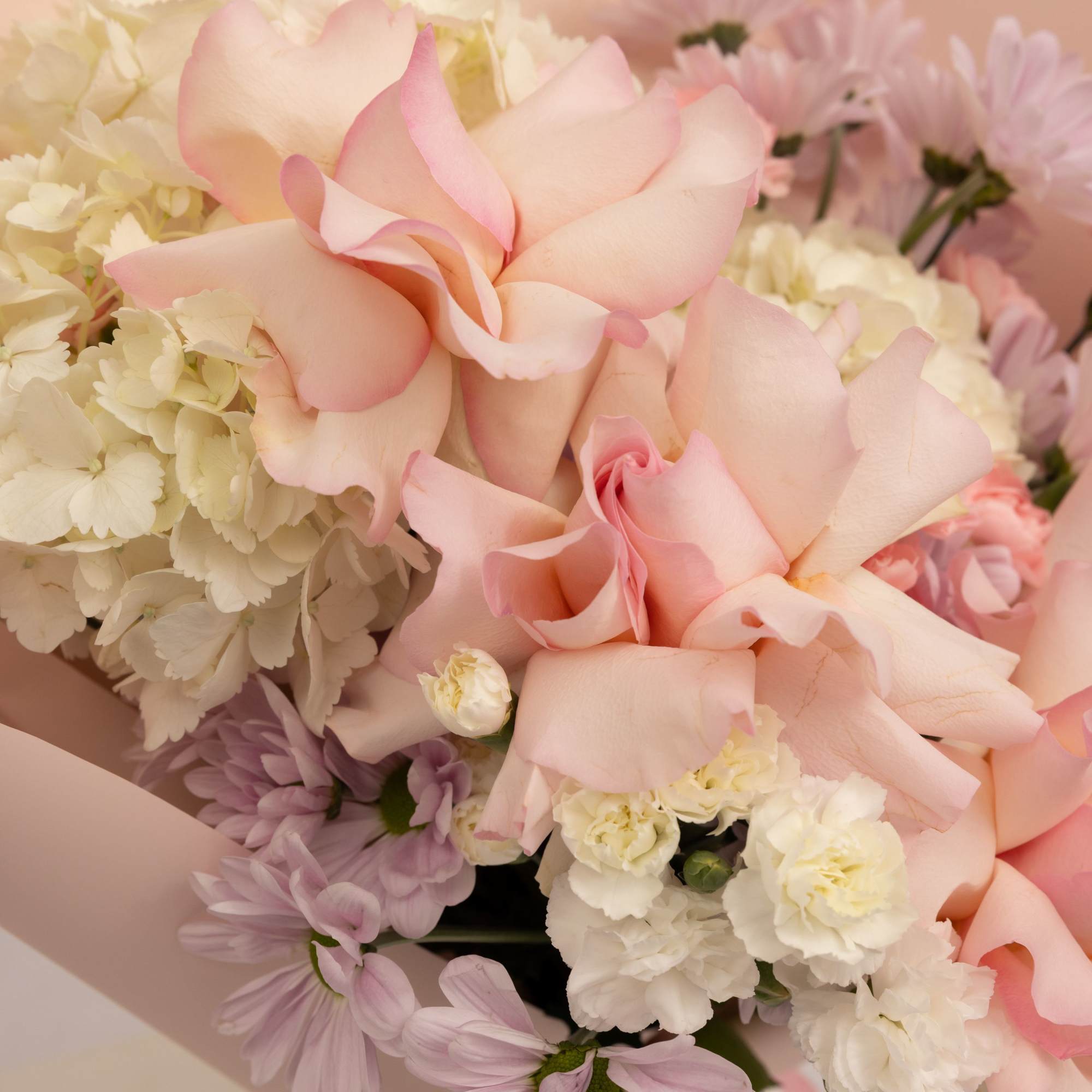 A soft and romantic bouquet in delicate blush tones, featuring pink roses