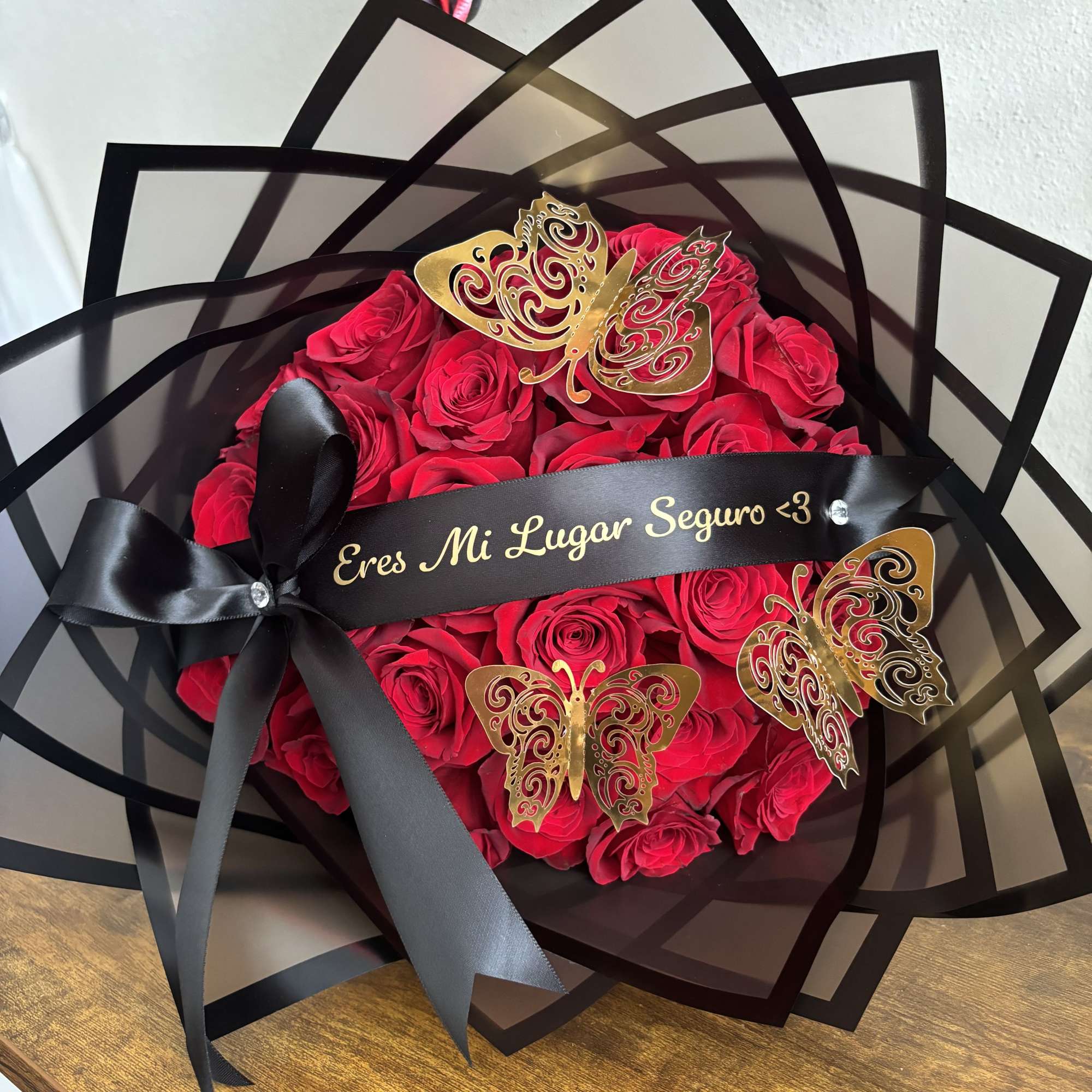 Red rose bouquet with black ribbon and butterfly decorations