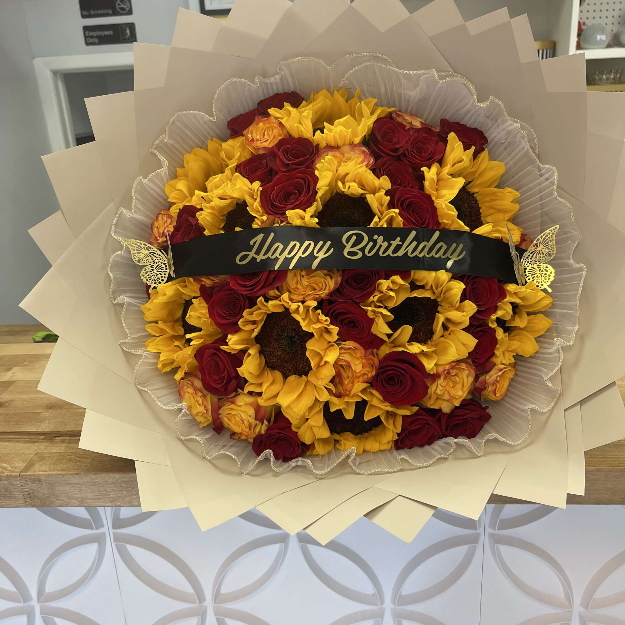 Bouquet of red roses and yellow sunflowers with a Happy Birthday ribbon