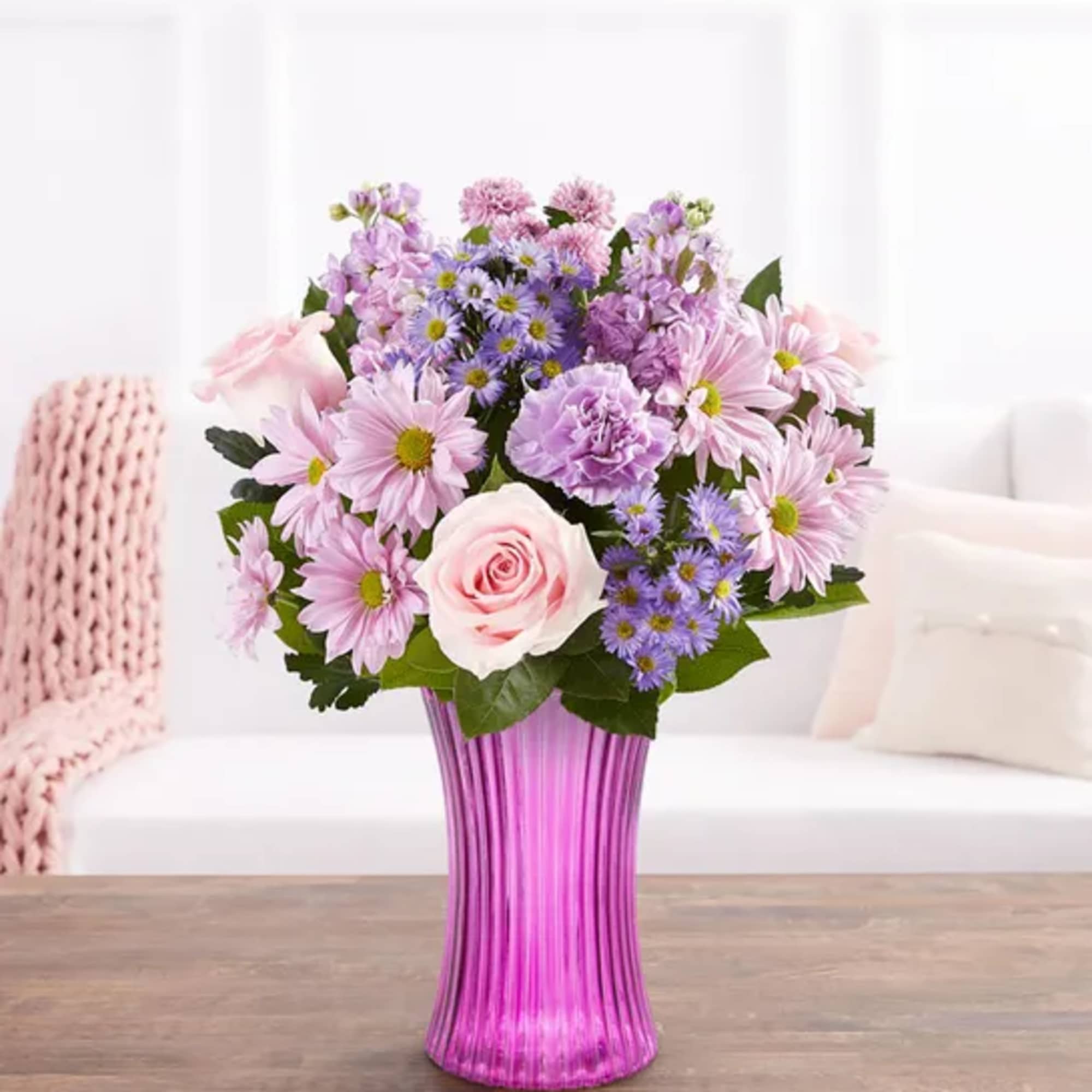 Pink and lavender mixed bouquet in a tall purple vase