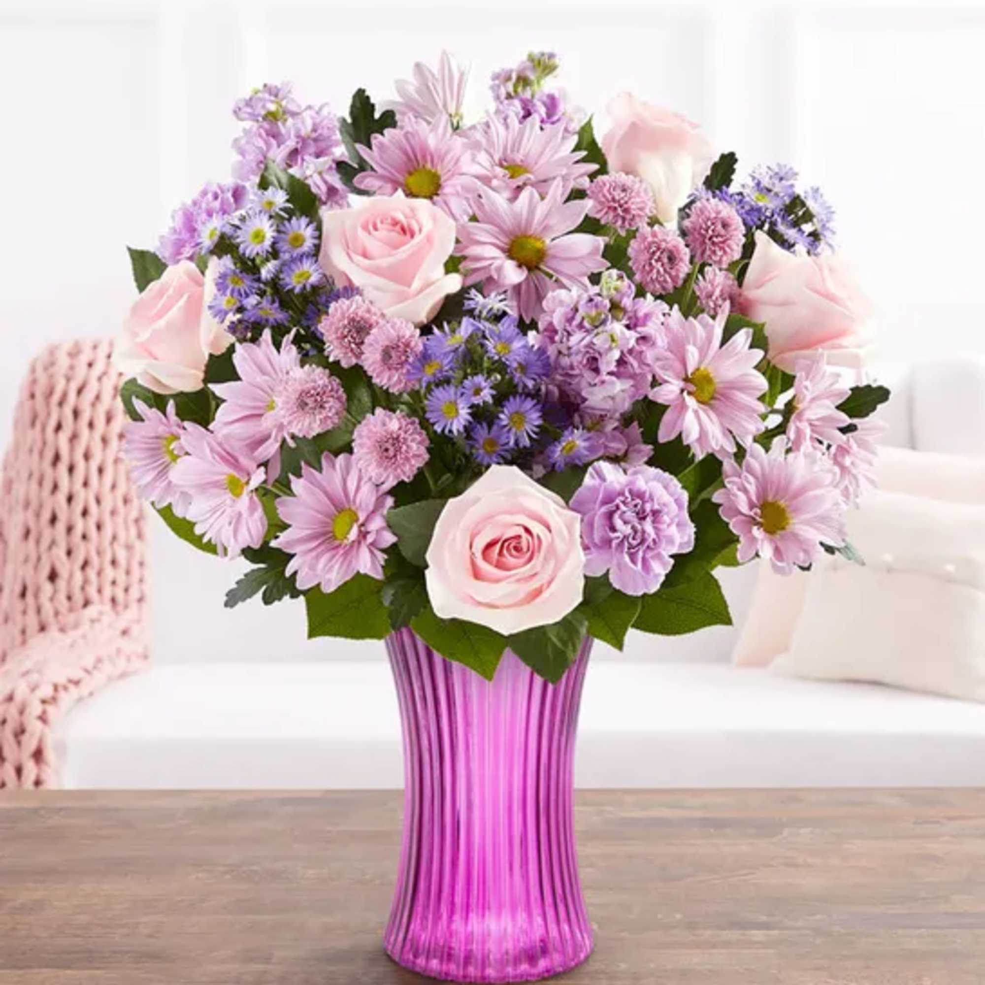 Pink and lavender mixed bouquet in a purple glass vase