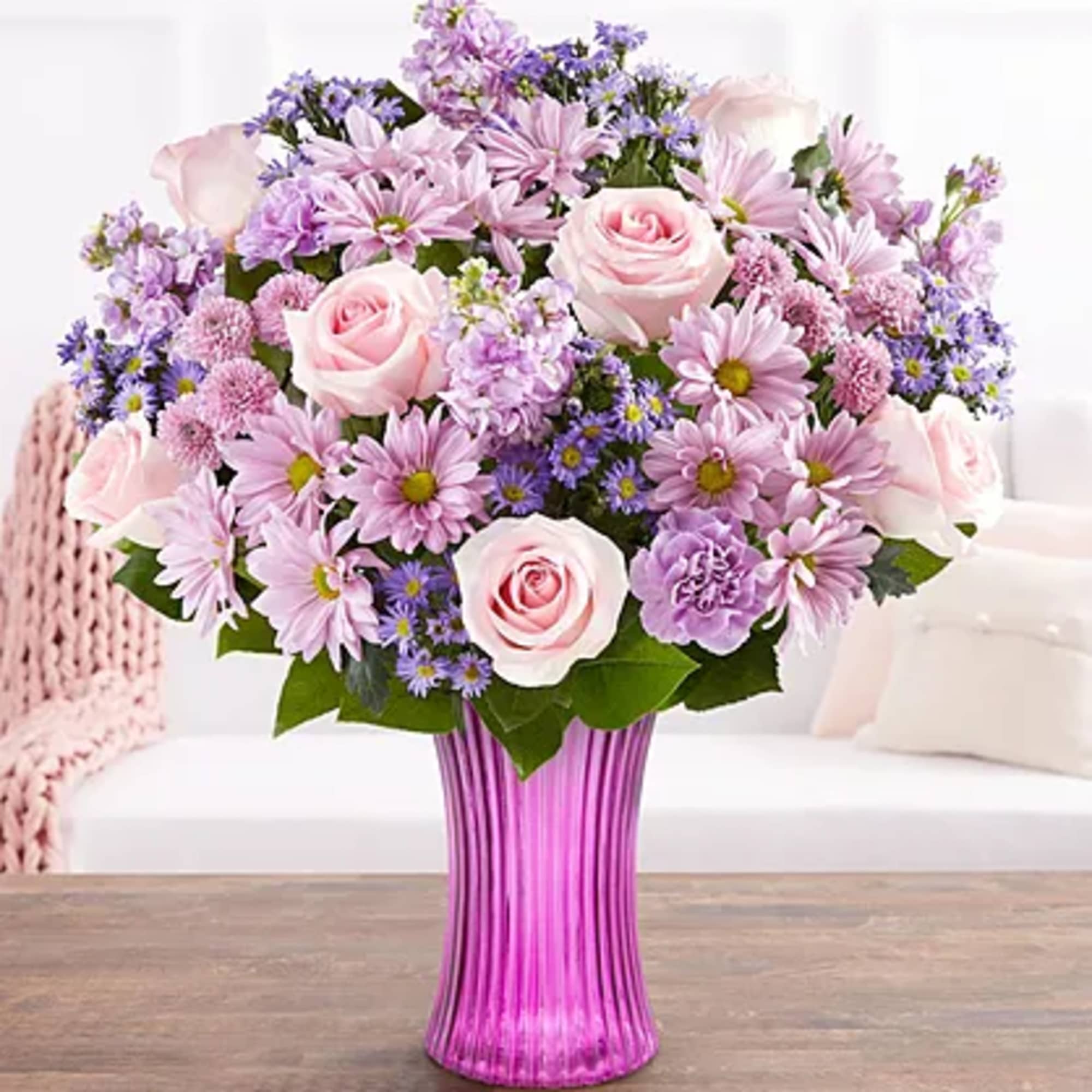 Pink and lavender mixed bouquet in a tall purple vase