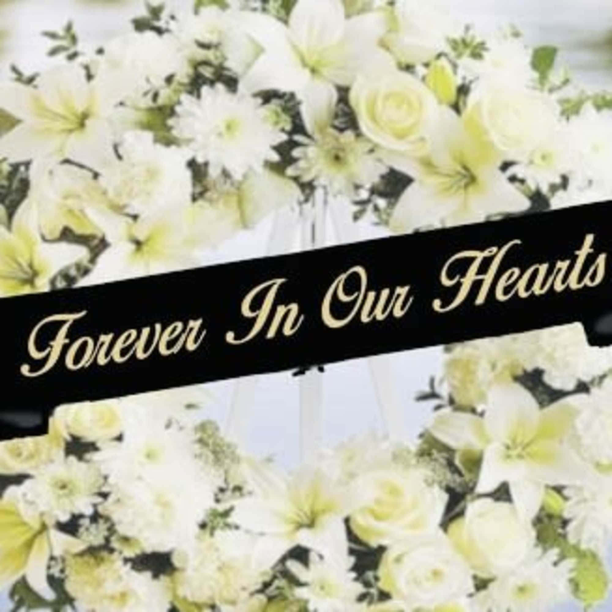 Stacked memorial ribbon tags take center stage in this sympathy arrangement, offering