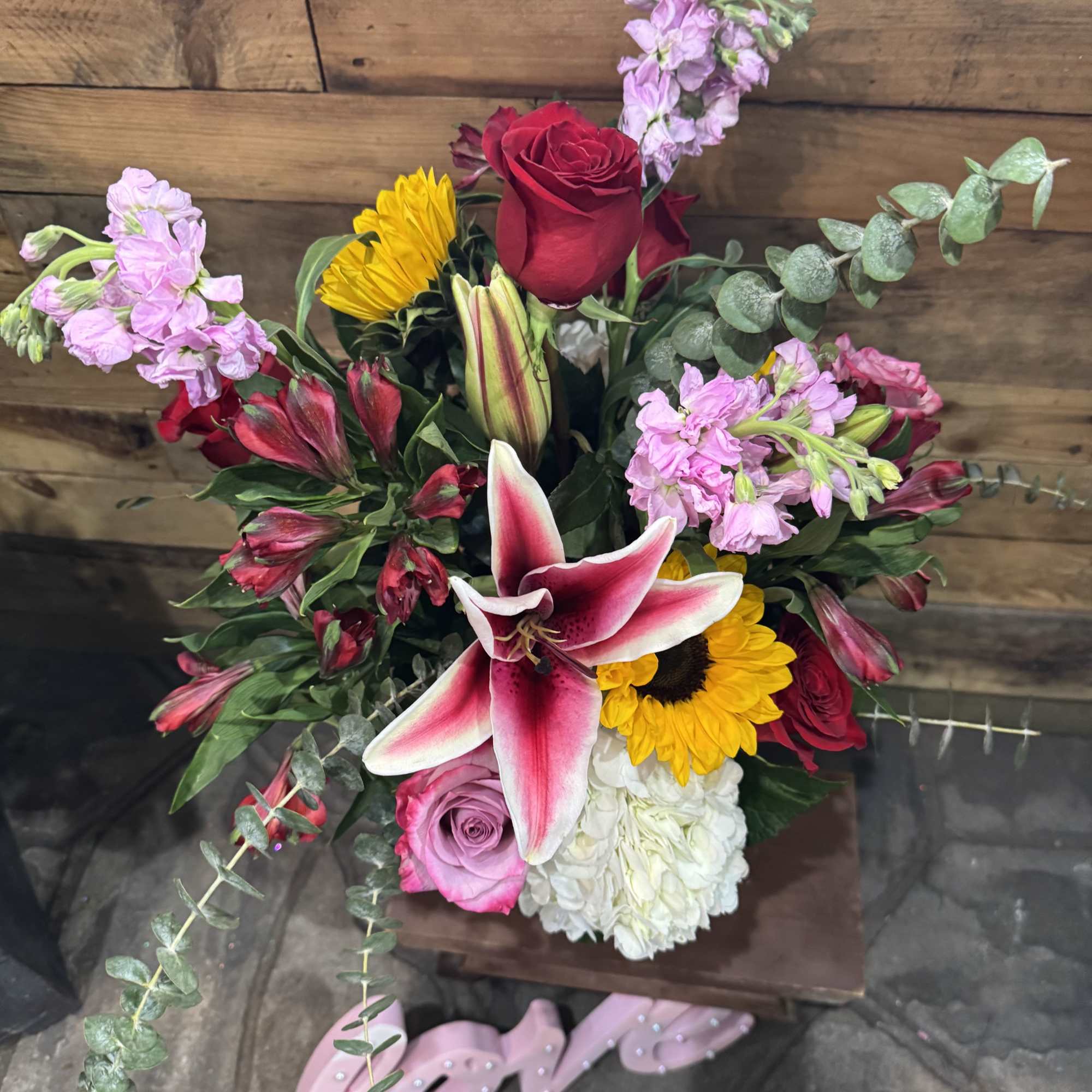 Mixed bouquet with red roses, pink lilies, sunflowers, and white hydrangea